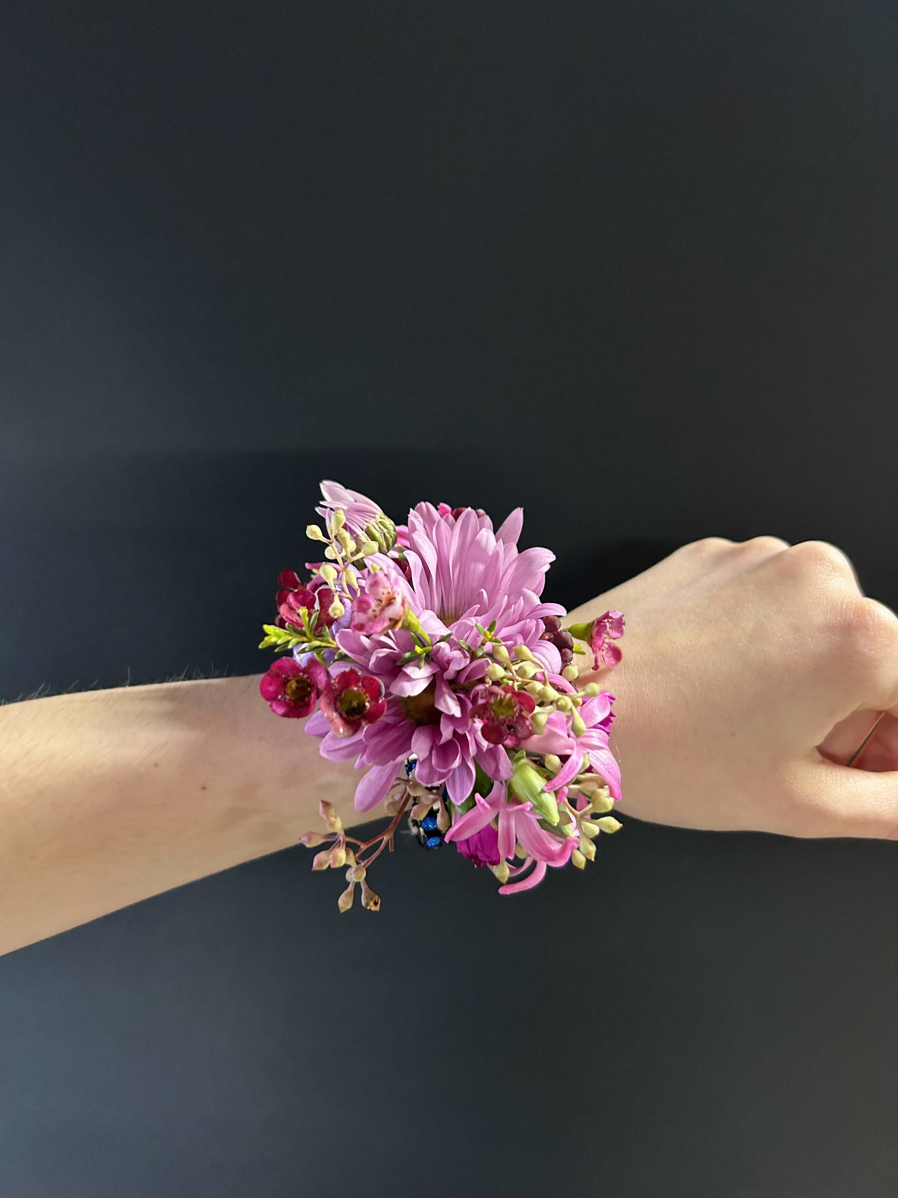 Pink flower wrist corsage on a person's wrist