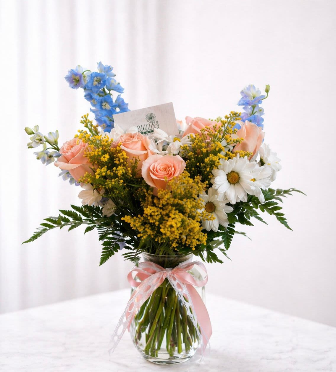 Mom's Sunny Smile - This vase arrangement is perform for the mother who is the light of the family. Brighten her day with yellow solidago, 6 peach roses, delphinium, and white daisies. 