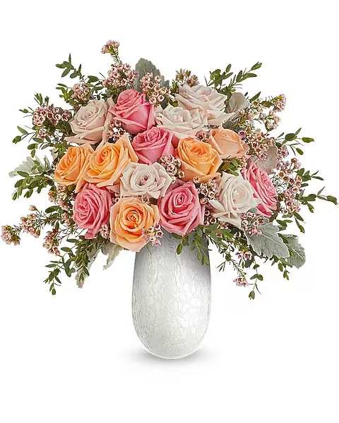 Opal Garden Bouquet - Delight Mom with the Opal Garden Bouquet, a lush mix of peach and pink roses beautifully arranged in the Amelia Vase. This elegant art glass keepsake adds soft shimmer and a fresh, heartfelt Mother's Day touch. The Opal Garden Bouquet is a beautiful Mother's Day floral arrangement featuring light pink, peach, and pink roses, accented with pink waxflower, dusty miller, and parvifolia eucalyptus, delivered in the Amelia Vase.  