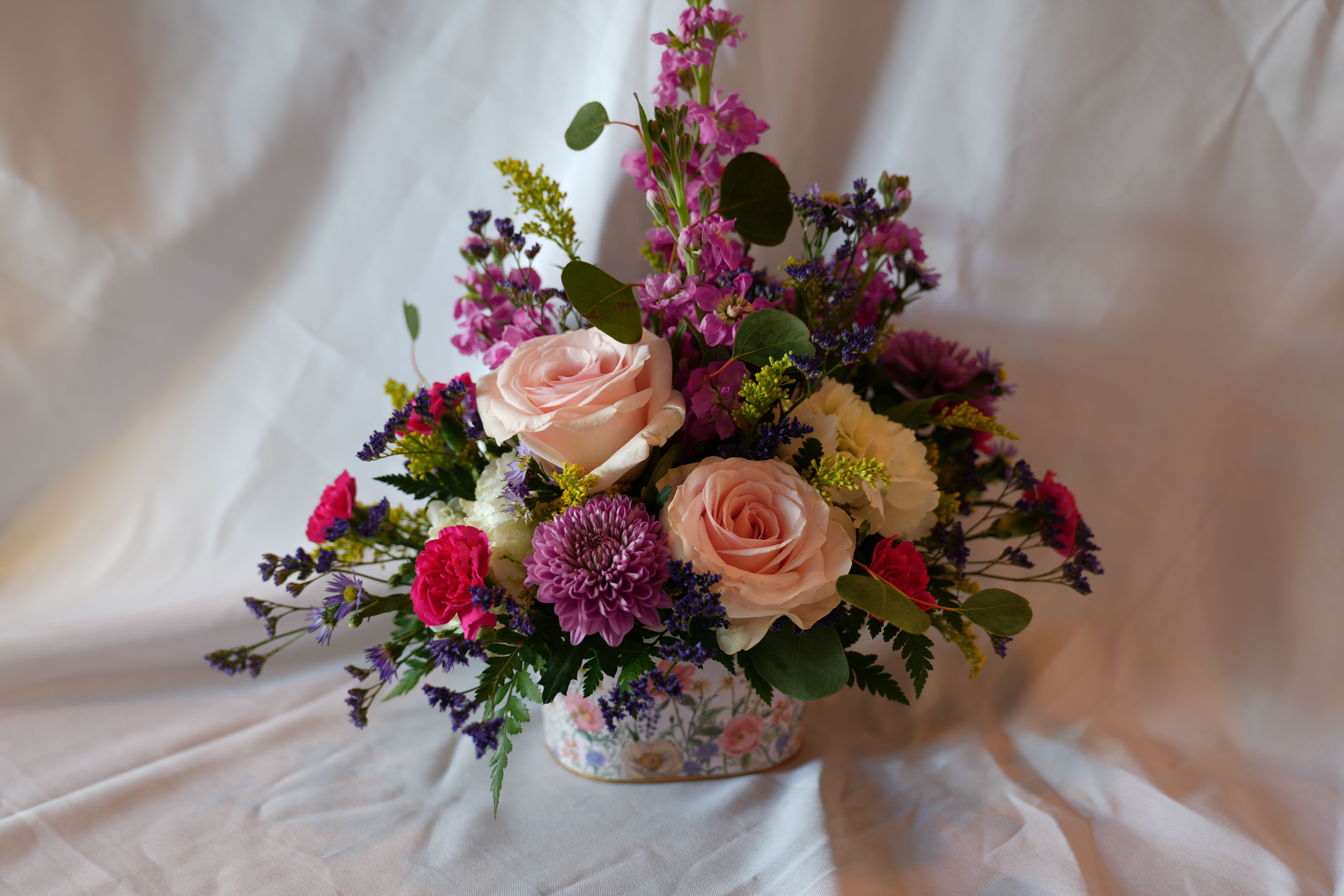 Wildflower Love - Wildflower Love is symbolic of joy and carefree simplicity. Blush roses and lavender notes mix with pops of yellow and vivid purple that Mom will notice the moment she walks in the room.  Give this to the woman who deserves to feel seen and celebrated, and let her know just how much you care. 