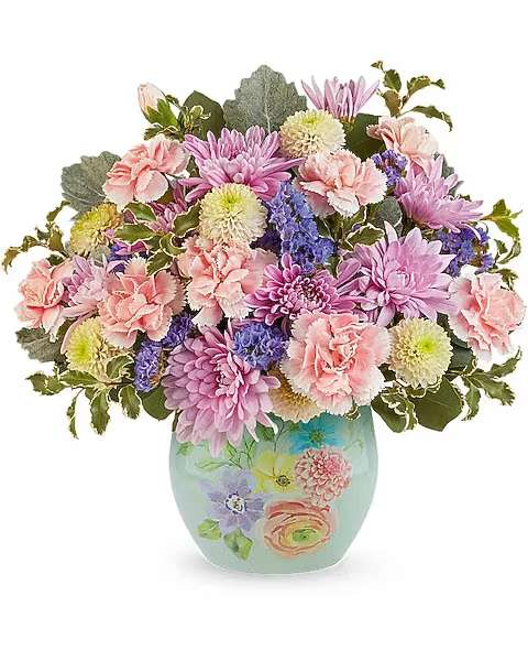 Pretty in Pastels Bouquet - Delight Mom with the Pretty in Pastels Bouquet, a sweet mix of soft pink, peach, and lavender blooms beautifully arranged in the Watercolor Garden Vase. This charming Mother's Day surprise brings fresh spring color and a keepsake she'll treasure. The Pretty in Pastels Bouquet is a sweet Mother's Day floral arrangement featuring miniature pink carnations, white button spray chrysanthemums, lavender cushion spray chrysanthemums, and purple sinuata statice, accented with silver dollar eucalyptus, dusty miller, and pitta negra, delivered in the Watercolor Garden Vase. 