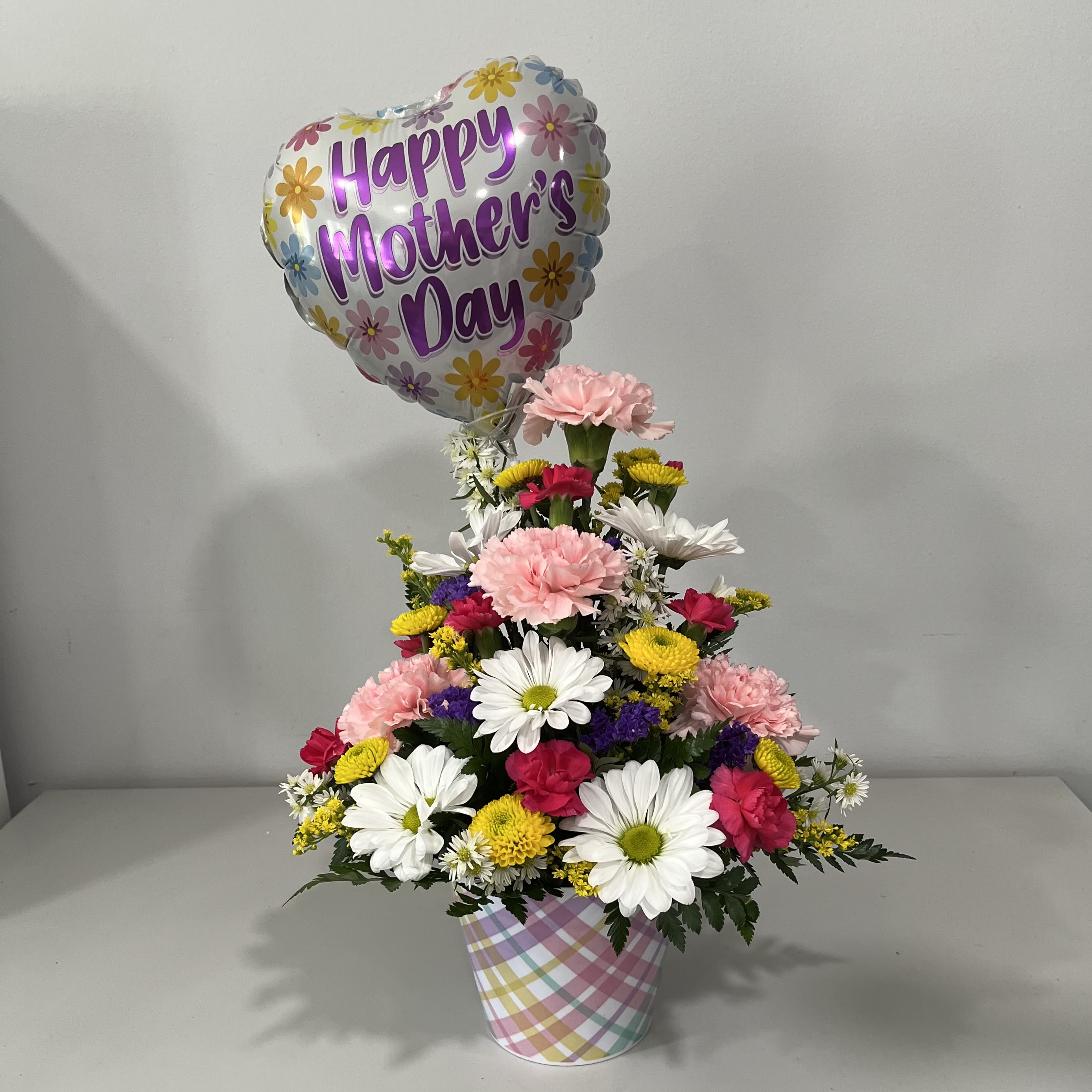 Mother's Day Basic with Balloon - Pastel Melamine Plaid Pot filled with Spring colored Carnations, Daisies and mini Carnations and a Happy Mothers Day 9" Mylar Balloon
