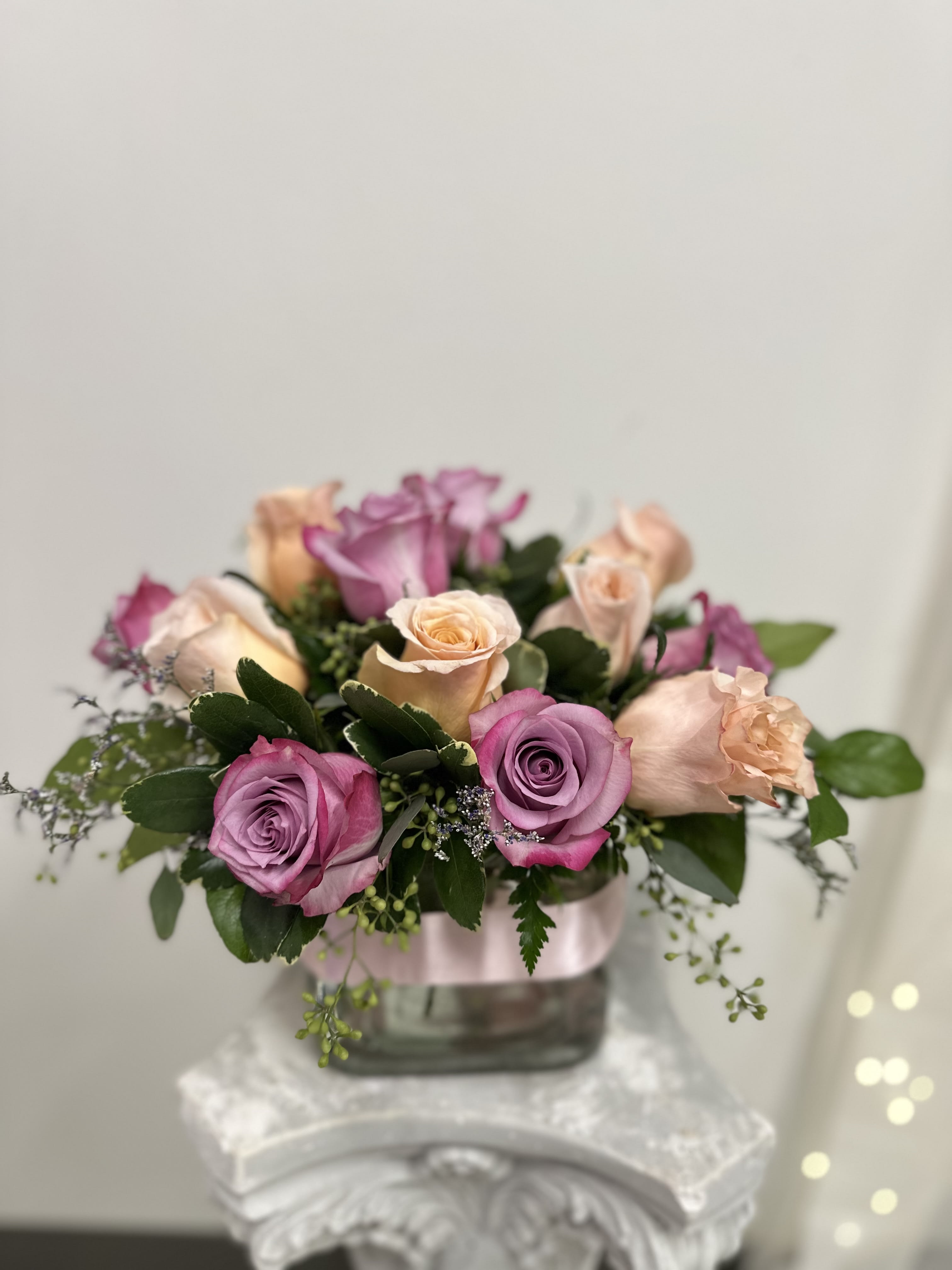 Arrangement of pink and peach roses in a glass vase