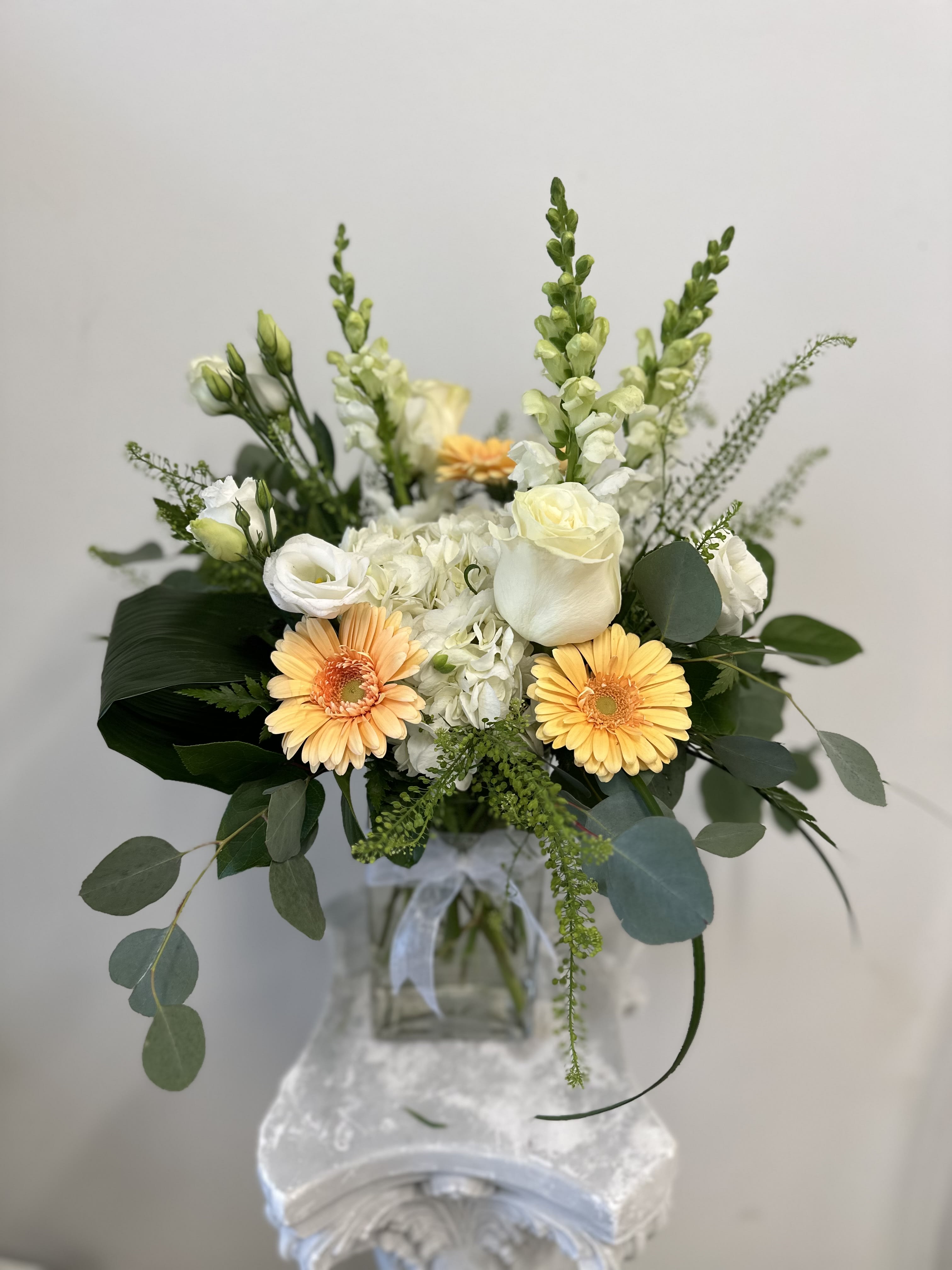 Bouquet of white and peach flowers in a glass vase