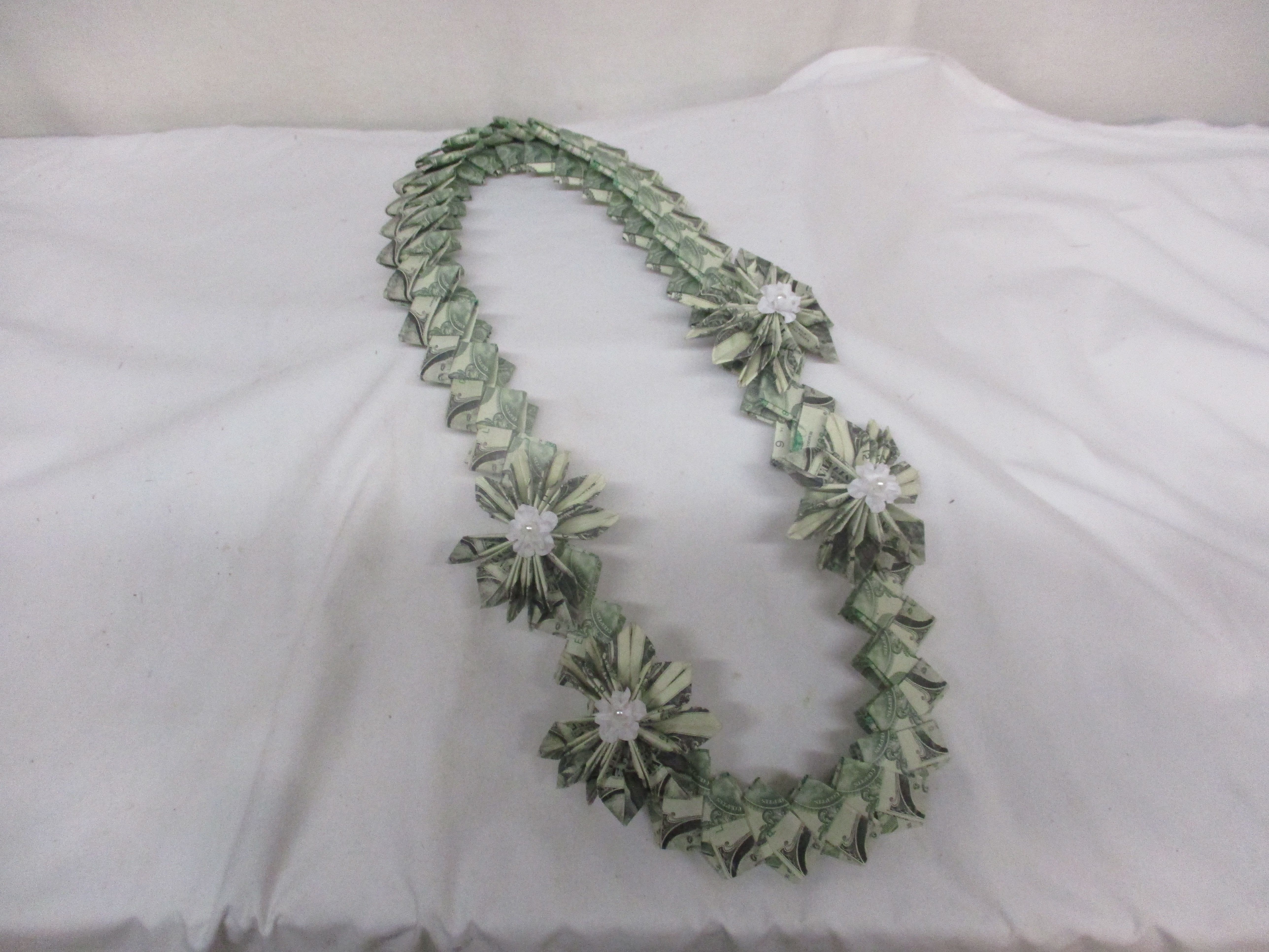 Dollar bill lei with small white flower accents