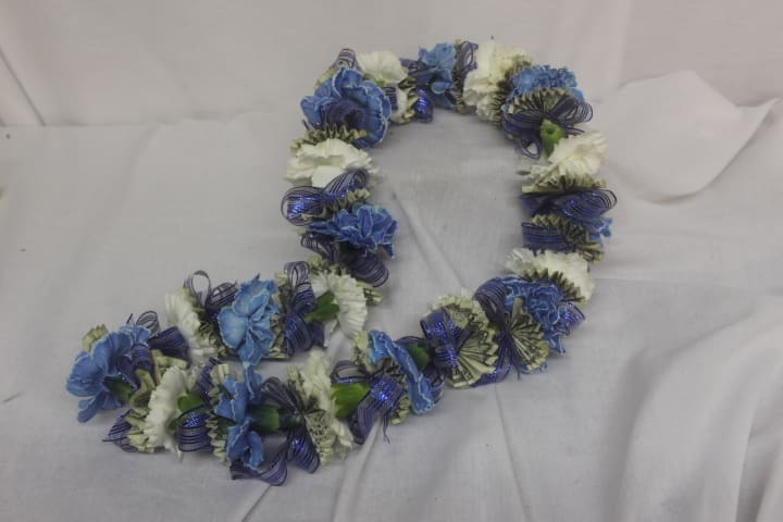 Blue and white flower lei on a light fabric background