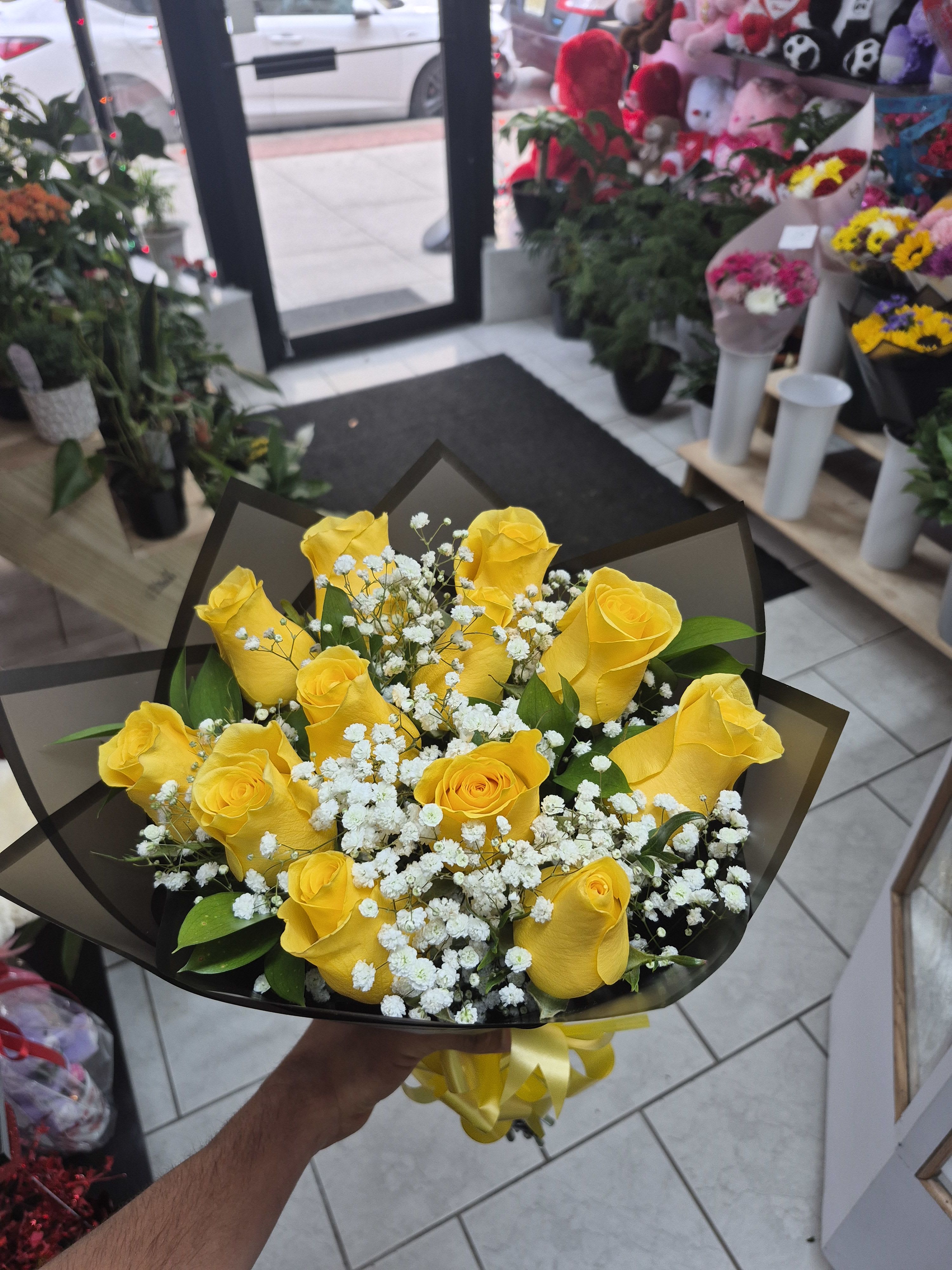 12 yellow roses - Un arreglo monocromático que irradia luz y optimismo. Está compuesto por una docena de rosas amarillas premium, seleccionadas por su color vibrante y pétalos firmes.Se entrelaza con delicadas ramas de gypsophila blanca (nube) que aportan suavidad, envuelto en un sofisticado papel coreano negro translúcido con cortes geométricos que resaltan el brillo de las flores.Perfecto para celebrar la alegría, el éxito de un ser querido o una amistad incondicional.