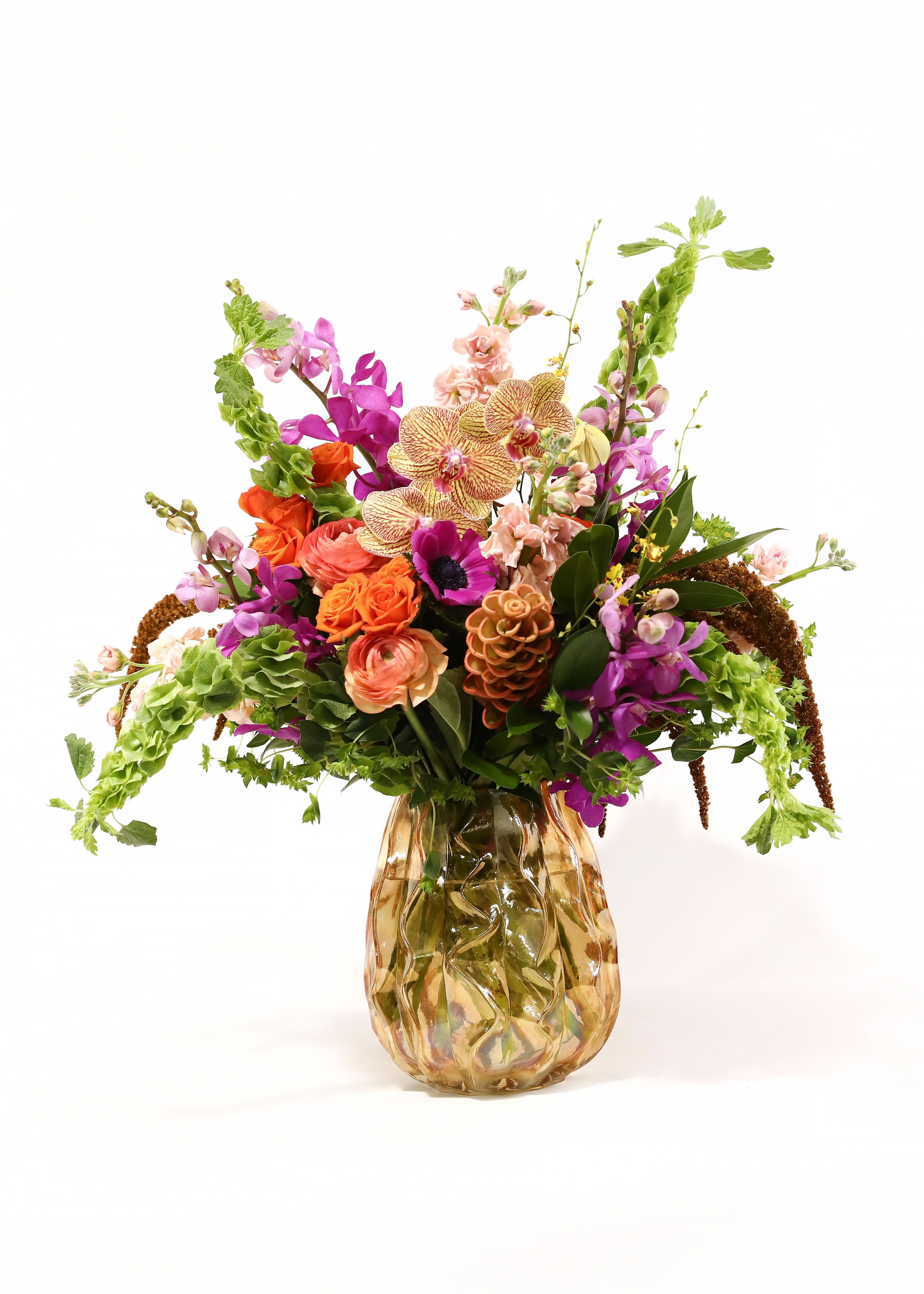 Colorful mixed flower arrangement in an amber glass vase