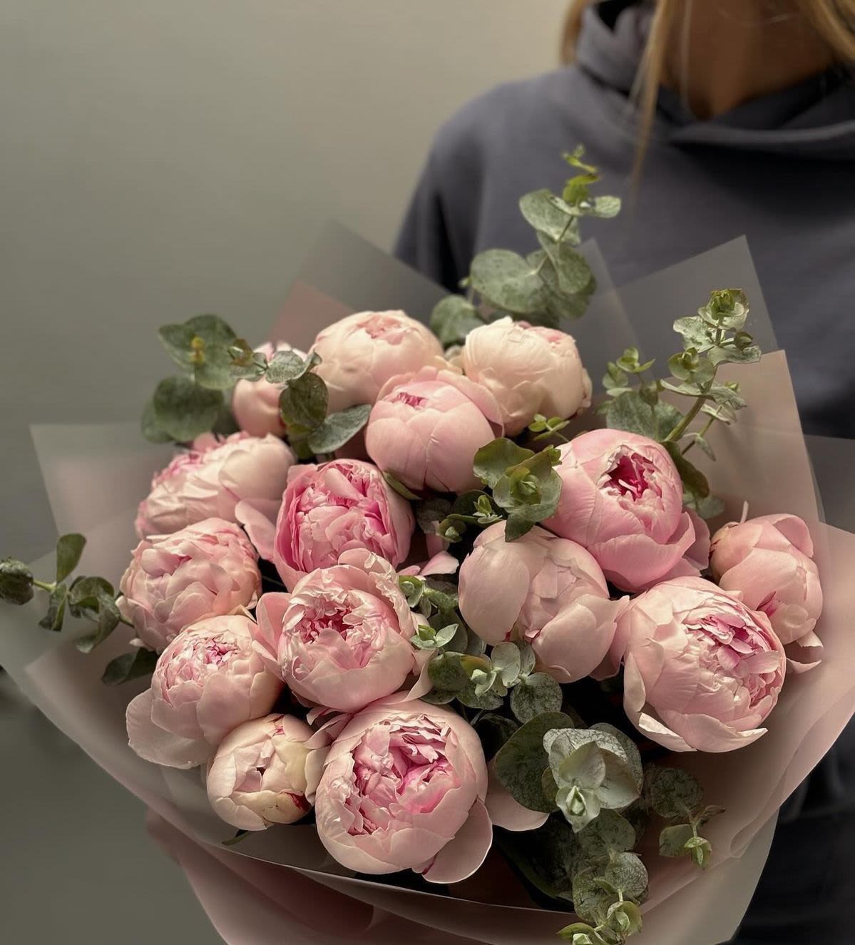 BP113 - Light Pink Peony Bouquet - It features a striking and luxurious gathering of light pink peonies, elegantly accented with eucalyptus. Bold, lush, and beautifully wrapped, it’s the ideal gesture for celebrating life's most beautiful moments.  Featured Blooms &amp; Seasonality: Peonies: Peak late Spring through early Summer. 