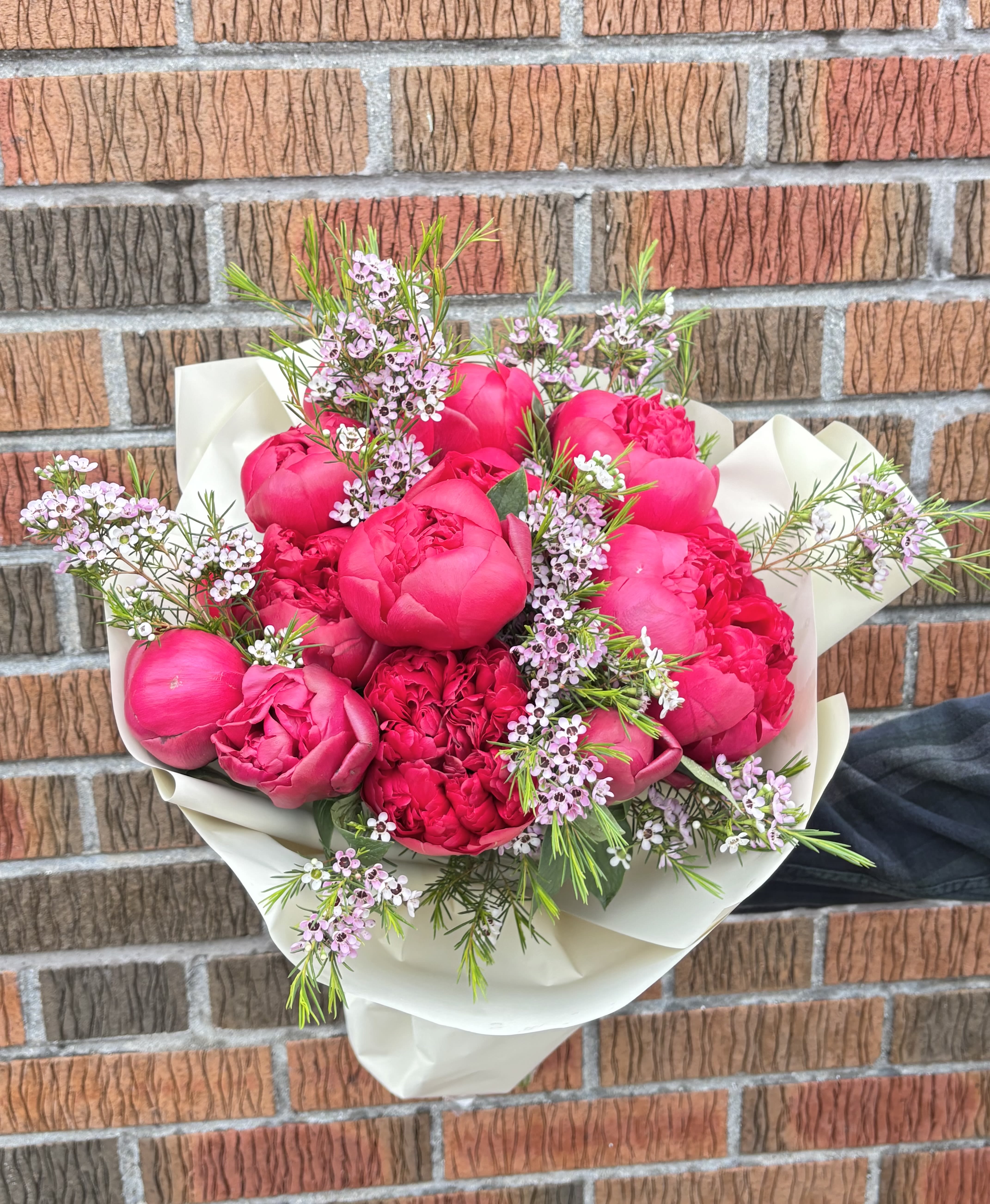 BP115 - Red Peony Bouquet - It features a striking and luxurious gathering of red peonies. Bold, lush, and beautifully wrapped, it’s the ideal gesture for celebrating life's most beautiful moments.  Featured Blooms &amp; Seasonality:  Peonies: Peak late Spring through early Summer. 