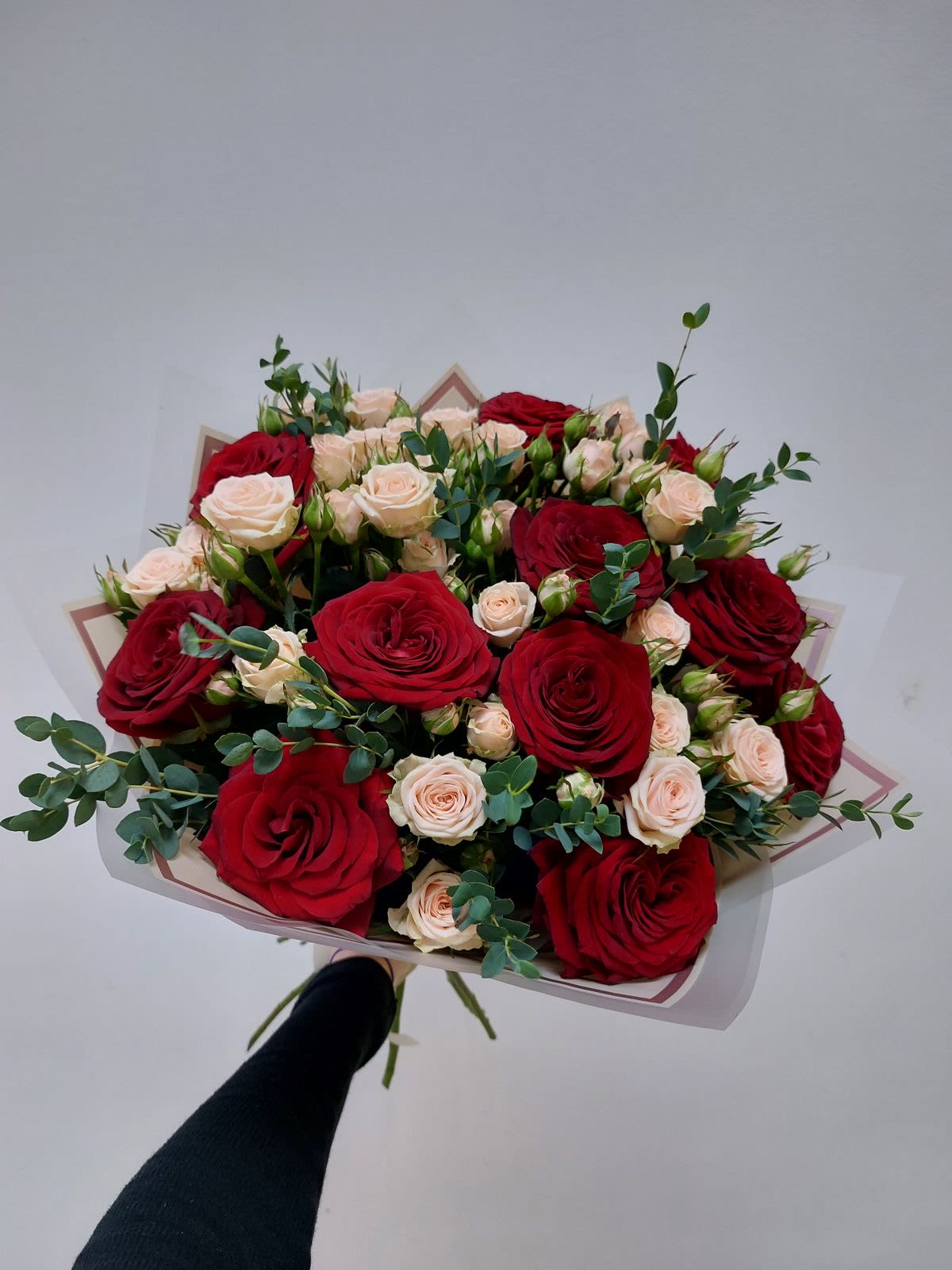 Bouquet of red and blush roses with eucalyptus wrapping