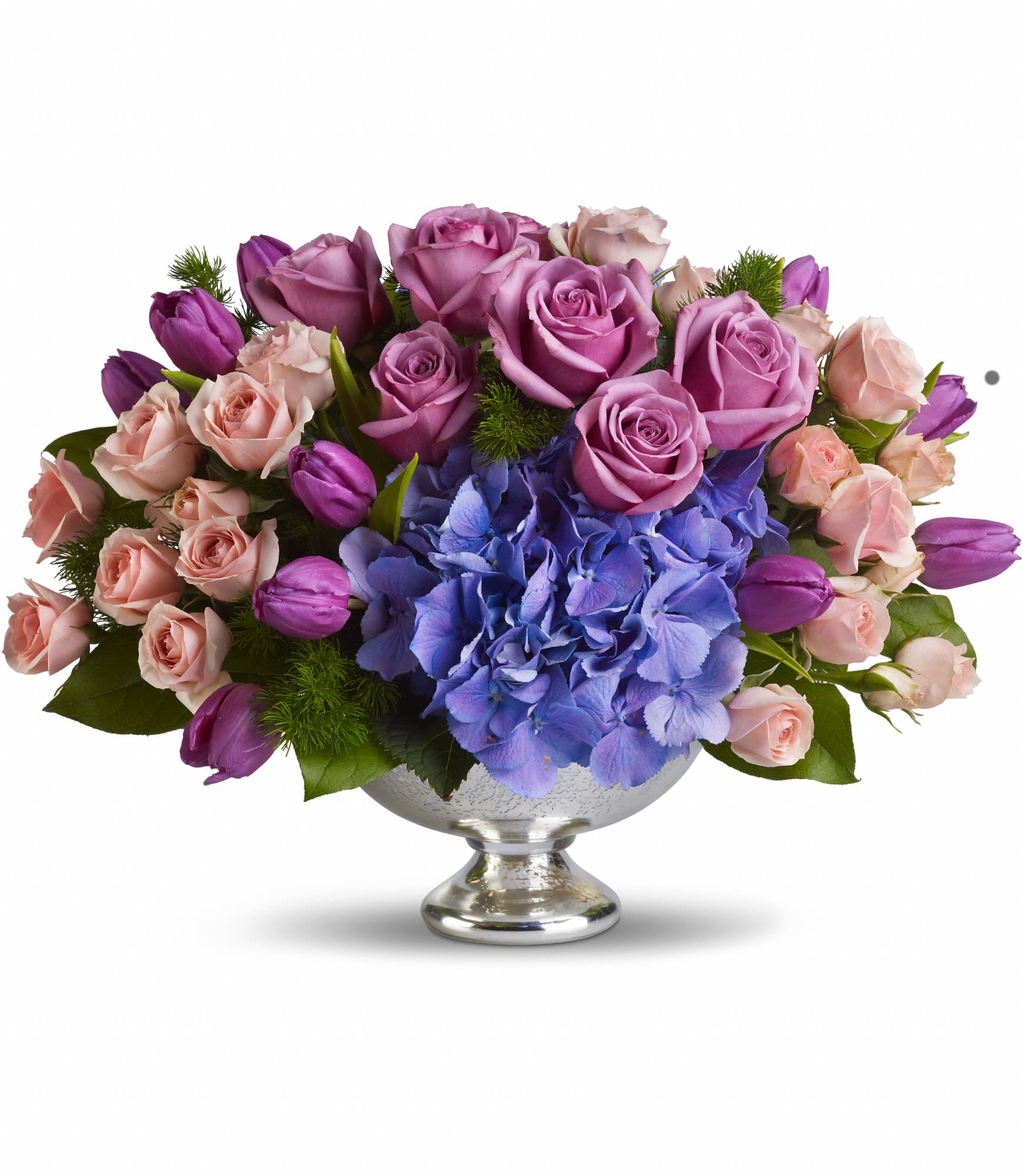 Lavender roses and blue hydrangeas in a silver pedestal bowl