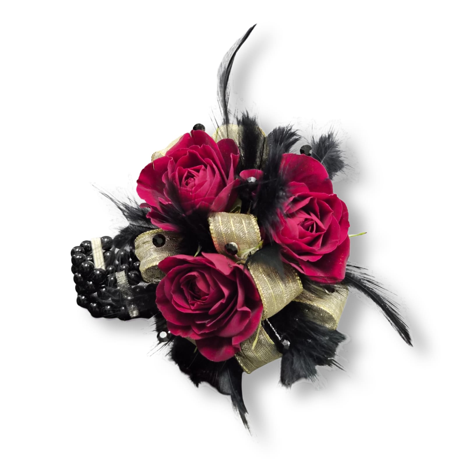 Gold &amp; Glam Wristlet - Deep magenta spray roses clustered into a compact wristlet make a bold first impression - the perfect prom corsage or formal accessory when you want her to feel glamorous and a little daring. This Gold &amp; Glam wristlet pairs rich red-pink roses with dramatic black feathers and metallic gold ribbon for a high-contrast, fashion-forward look that reads luxe against eveningwear. The black beaded bracelet base keeps the piece wearable and secure, so she'll feel confident and celebrated as she steps into the spotlight.  Each wristlet centers tightly arranged spray roses for a full, textured bloom, finished with black feathers for movement and gold ribbon for metallic shimmer. Size and fit are designed for comfort on the wrist; handle with care and store flat until the moment of gifting to keep the ribbon and feathers pristine.
