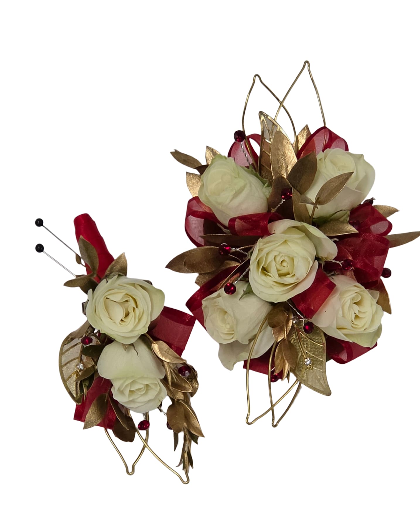 Golden Manor Set - Creamy white spray roses framed with metallic gold leaves and deep red ribbon loops create an instantly elegant prom corsage and boutonniere set that reads formal and celebratory. Perfect for prom, weddings, or any dressy event, the Golden Manor Set gives the person you're honoring a classic, made-for-the-moment look-the wristlet corsage sits fuller and layered while the matching boutonniere is compact and perfectly coordinated.  The wristlet corsage and boutonniere are built from clusters of white spray roses, accented with gold decorative leaves, floral wire, and decorative beads, plus red rhinestone highlights that catch the light. The larger wristpiece offers a plush silhouette for the wrist; the boutonniere mirrors the same materials in a smaller profile and includes secure corsage pins and wire loops for easy attachment. Textural contrast between the soft petals and metallic accents gives a luxe, photograph-ready finish. 