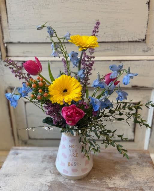 Mixed bouquet in a white vase with yellow daisies and pink tulips