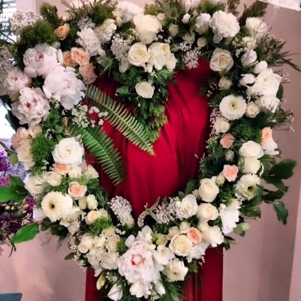 couer D'Amour - Hand Crafted floral art for a Funeral piece that is a statement. Premium flowers only. Sword fern dashes across the heart wreath. Flowers are not cookie cutter or typical, I take my time on this piece until it is perfect for loved ones. Roses, Gerbera daisies, freesia, orchids, hydrangea, delphinium, dahlia.
