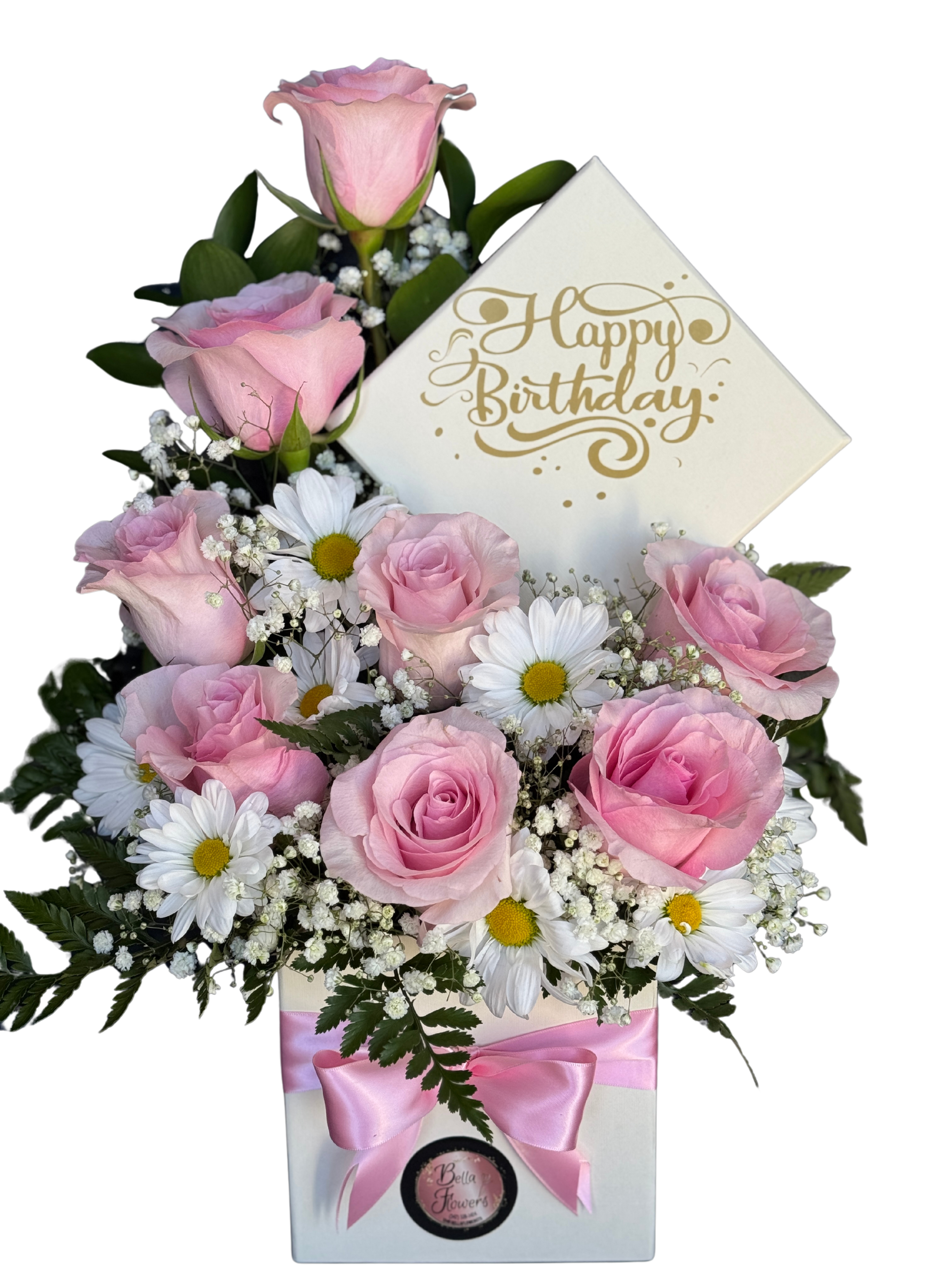 Birthday Small - Soft pink roses with crisp white daisies and delicate baby's breath arranged in a chic white gift box create a gentle, cheerful birthday bouquet that feels both personal and celebratory. This birthday arrangement is designed to make the person you're thinking of feel seen-soft pastels, a rounded full composition, and a gold "Happy Birthday" card rising behind the blooms say "celebrate you" at first glance.  Wrapped with a pink satin ribbon and presented in a sturdy white gift box, the display includes a printed birthday card for your message and arrives ready to brighten a table or desk. The mix of roses, daisies, and airy filler gives pleasing texture and lasting visual impact; order as a thoughtful small birthday surprise when you want to send warm, cheerful wishes in a compact, easy-to-display package.