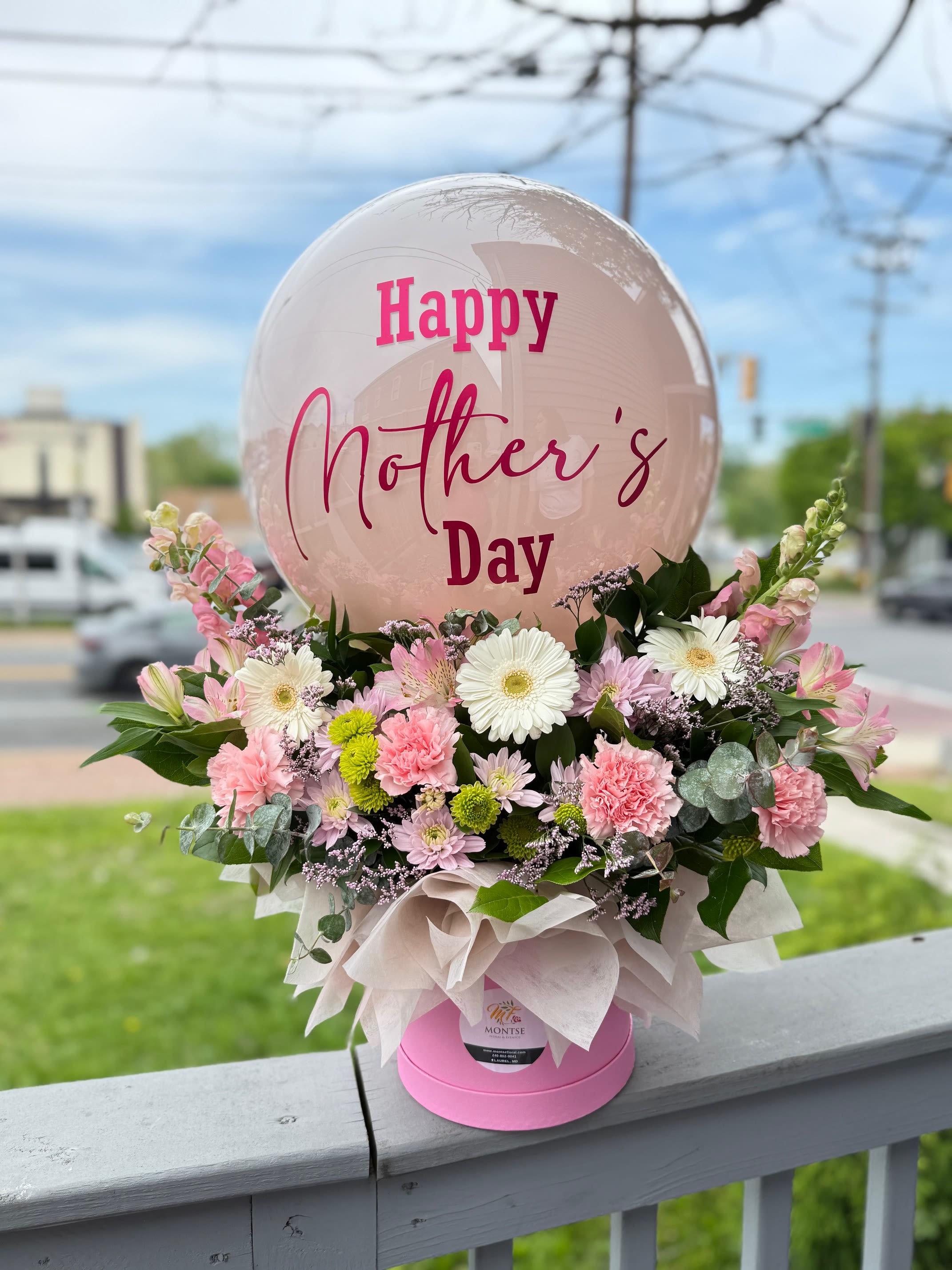 Stephanie  - Arrangement of white gerberas, carnations, alstroemeria and chrysanthemums,  and eucalyptus  with  blush . "Happy Mother's Day" balloon and pink box 