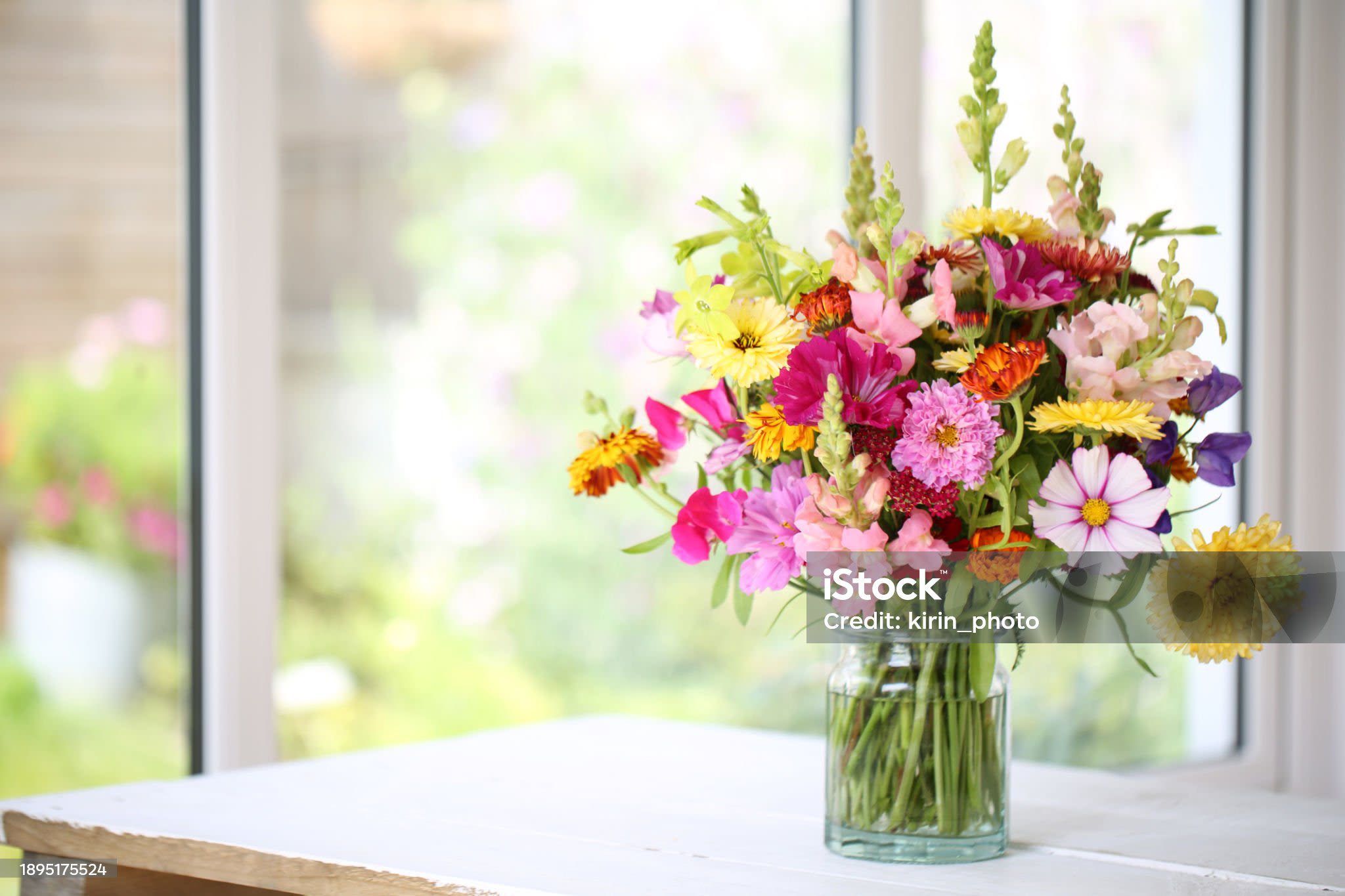 Mixed bouquet of colorful flowers in a clear glass vase