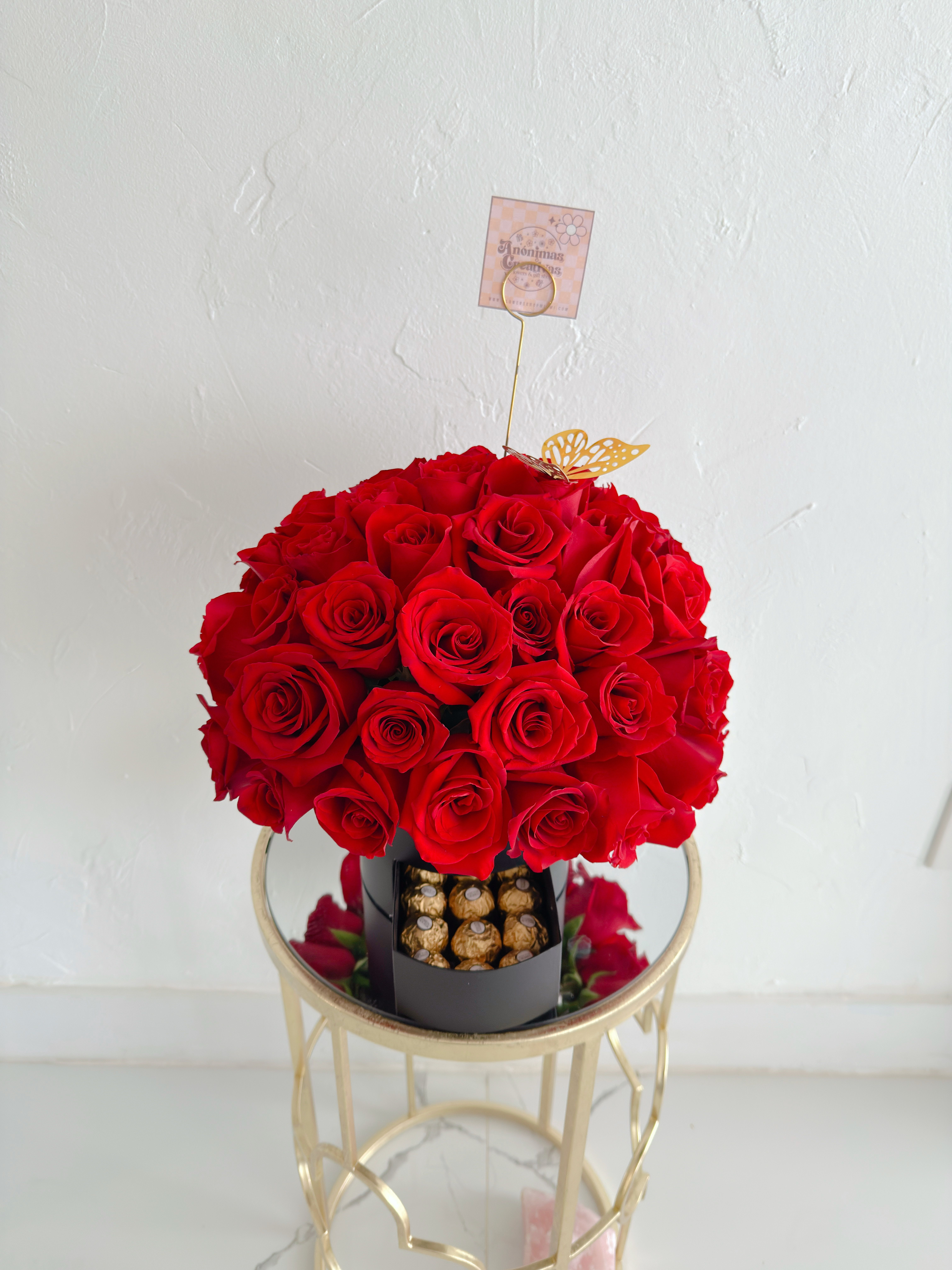 50 Roses &amp; Bombones  - An elegant and captivating arrangement featuring 50 premium red roses, beautifully arranged in a round shape to create a striking and sophisticated look ️  Presented in a modern base, this design includes a delicate compartment with delicious chocolates, making it the perfect gift for a complete and memorable surprise. The decorative top detail adds a unique and special finishing touch that enhances its beauty.  Perfect for occasions like anniversaries, birthdays, or to express an unforgettable “I love you.”   Includes:  * 50 fresh red roses * Elegant box with chocolates * Modern and exclusive design  A gift that combines flowers and sweetness in one unforgettable experience 
