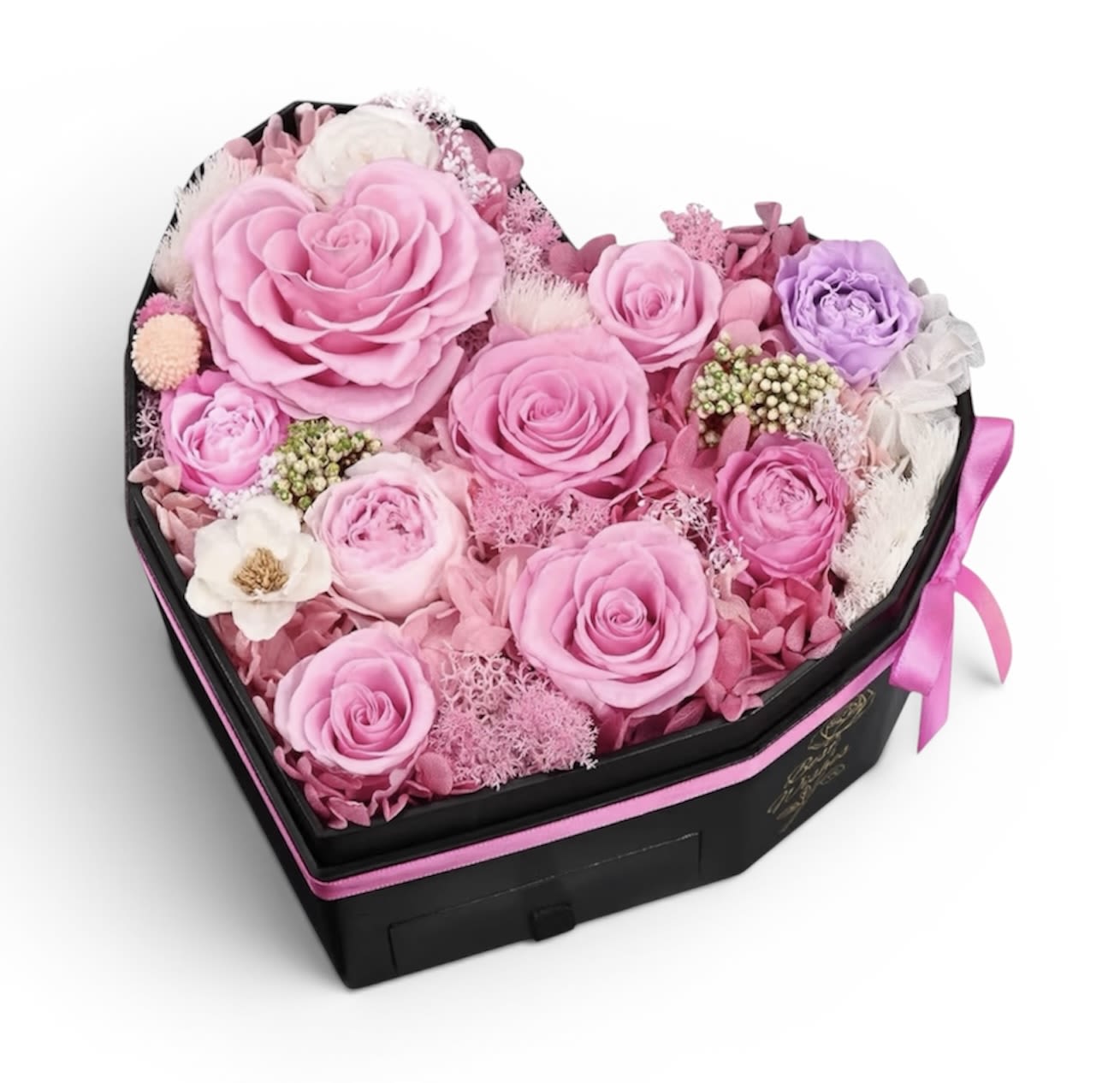 Timeless Preserved Pink Rose Garden Mix  - A lush cluster of preserved pink roses packed into a black heart-shaped presentation box creates an immediately romantic, keepsake-worthy gift for anniversaries, birthdays, Mother's Day or a "just because" surprise. The large focal rose surrounded by several smaller roses, soft pink filler and delicate white accents form a layered, feminine composition that reads both celebratory and intimate-perfect when you want her to feel truly seen and adored.  The preserved roses and blooms keep their texture and petal detail without daily watering, making this an elegant, low-maintenance keepsake that will continue to charm long after the moment. Give this to the person whose day you want to brighten-whether marking an anniversary, saying "I love you," celebrating a birthday, or honoring Mom on Mother's Day. Dimensions and exact flower counts are preserved in the product details at checkout; because these are preserved blooms, gentle handling and avoiding direct sunlight will help maintain their color and form.  * Dimensions : 8.7 x 8.3 x 5