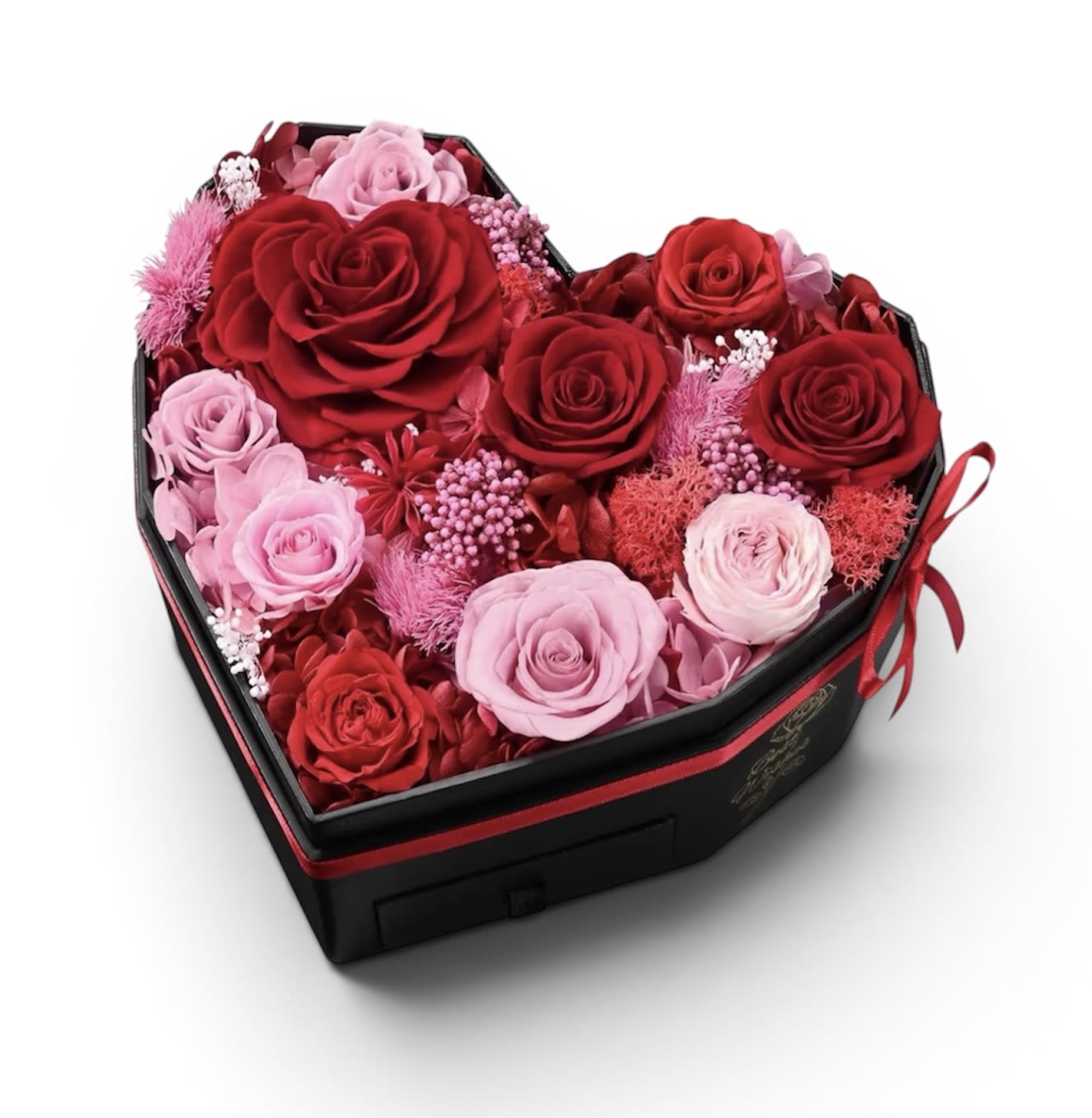 Classic Premium Preserved Rose Mixed Ensemble - A heart-shaped black gift box brimming with preserved roses creates an unforgettable romantic statement - perfect as a Valentine's Day bouquet, anniversary roses, Mother's Day or a surprise "just because" for the one you love.   The preserved-style presentation gives the arrangement a luxuriously layered look and the long-lasting nature suggested by the printed background means more time to enjoy the sentiment without a vase.  Choose this ensemble when you want her to feel genuinely cherished - it's the kind of gift that reads thoughtful, romantic, and memorable. Presented in a compact heart box, it's travel-ready and makes an immediate impression; no vase needed and no fussing with care beyond keeping it away from direct sunlight and humidity to preserve its lasting beauty.  Dimensions : 8.7 x 8.3 x 5