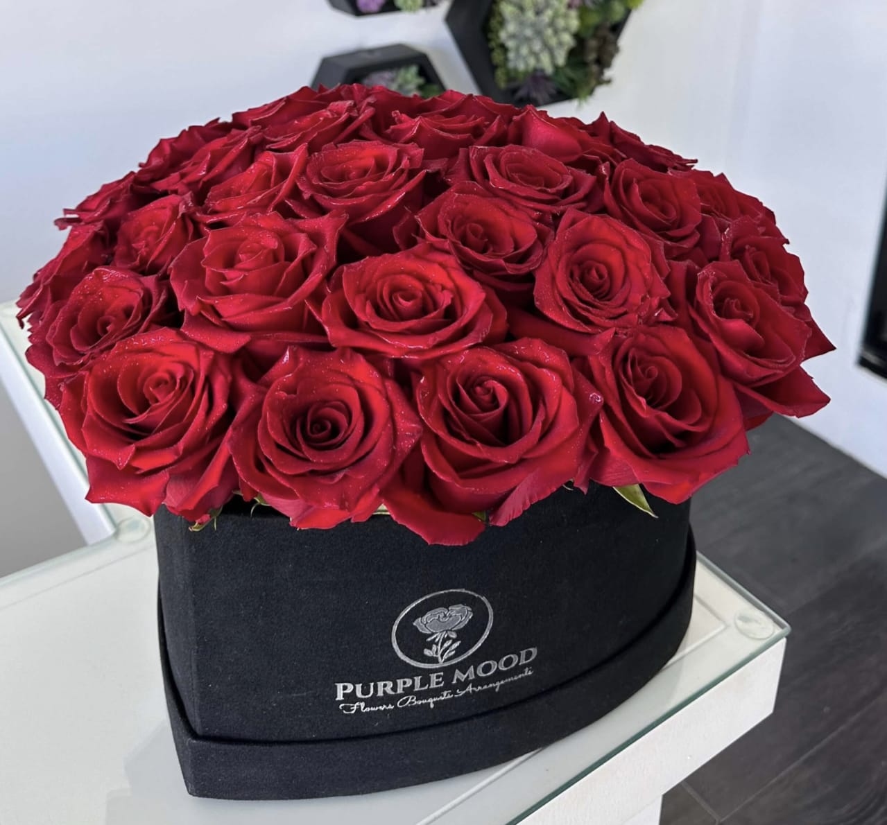 Black Heart Box - Black velvet heart box with real red roses, approximately 28-33 stem. Bold and dramatic, our Black Heart Box is designed for those who love luxury with an edge. Lush, velvety red roses are hand-arranged in a chic black velvet heart-shaped box, creating a striking contrast that symbolizes both passion and strength. Perfect for romantic gestures, anniversaries, or special celebrations, this arrangement makes a statement of love that cannot be ignored.  •    Premium red roses arranged in a heart-shaped black velvet box     •    Elegant, dramatic design with a modern luxury touch     •    Symbolizes deep passion, romance, and timeless devotion     •    Perfect for anniversaries, Valentine’s Day, or unforgettable surprises  Box size: approximately 11” x 11”