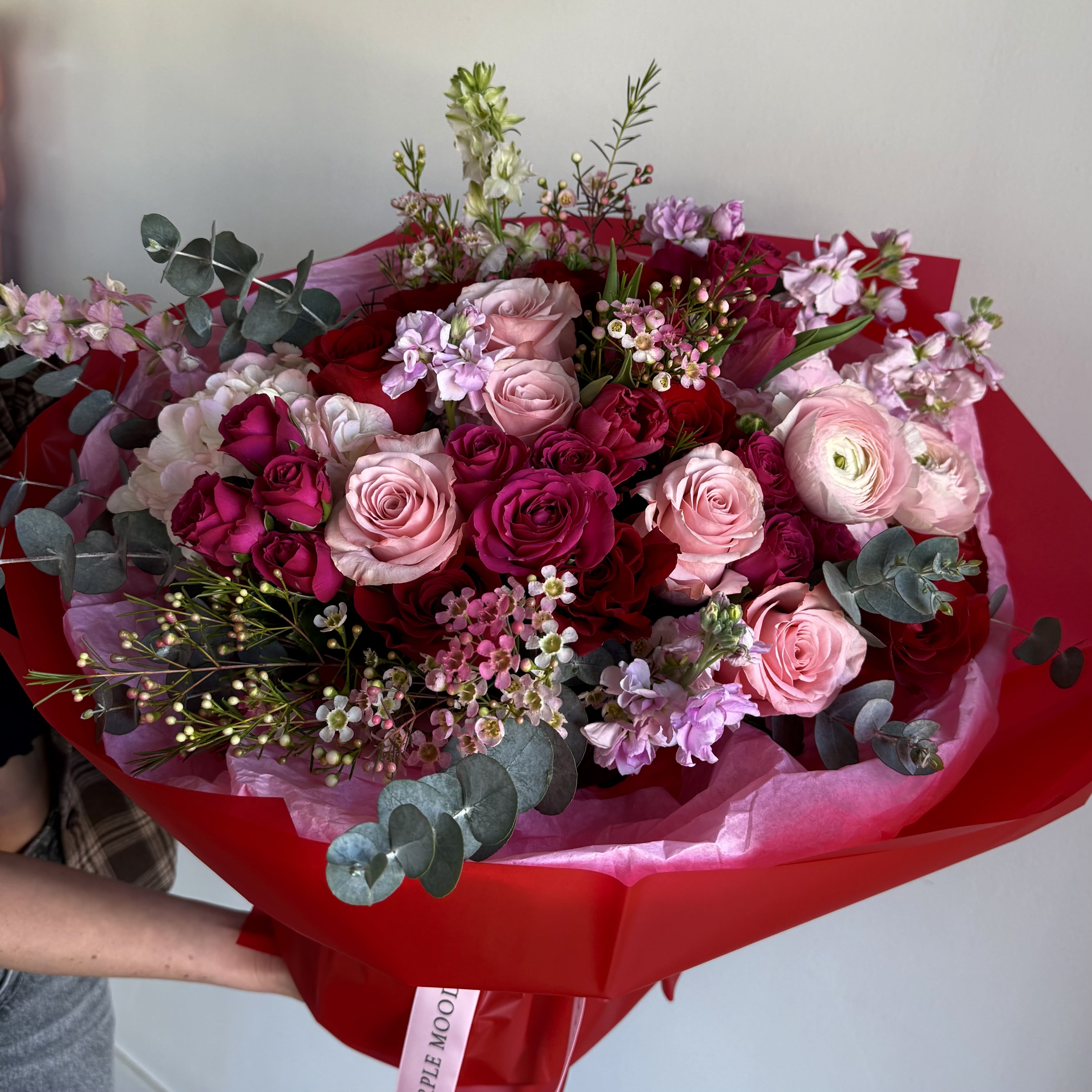 Red Accent Bouquet - Red Accent Bouquet Passionate and refined, the Red Accent Bouquet is a vibrant mix of rich reds and soft pinks, wrapped in elegant blush tones. Perfect for celebrating love, admiration, or any moment that calls for a bold, romantic gesture.      •    A striking harmony of deep and delicate hues     •    Wrapped in elegant blush paper with a satin ribbon     •    Available in Standard, Deluxe, and Premium sizes     •    Ideal for anniversaries, romantic surprises, or heartfelt occasions  VASE NOT INCLUDED