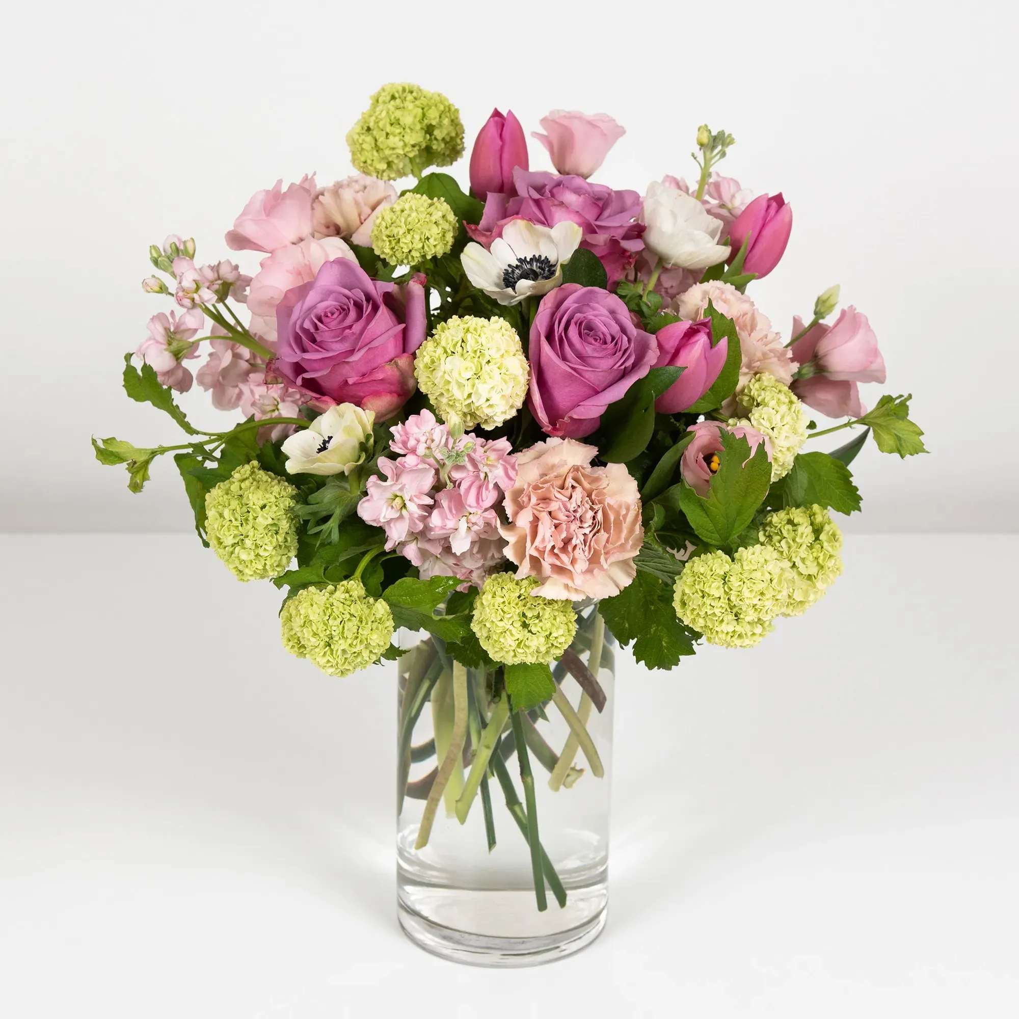 Spring Awakening - Spring Awakening Bouquet: Embrace the beauty of spring with this enchanting arrangement. Featuring vibrant purple roses, delicate purple tulips, fragrant blush stocks, soft pink lisianthus, Anemone, and lush green viburnum, this bouquet is a celebration of nature's renewal. Perfect for bringing a touch of elegance and freshness to any space."