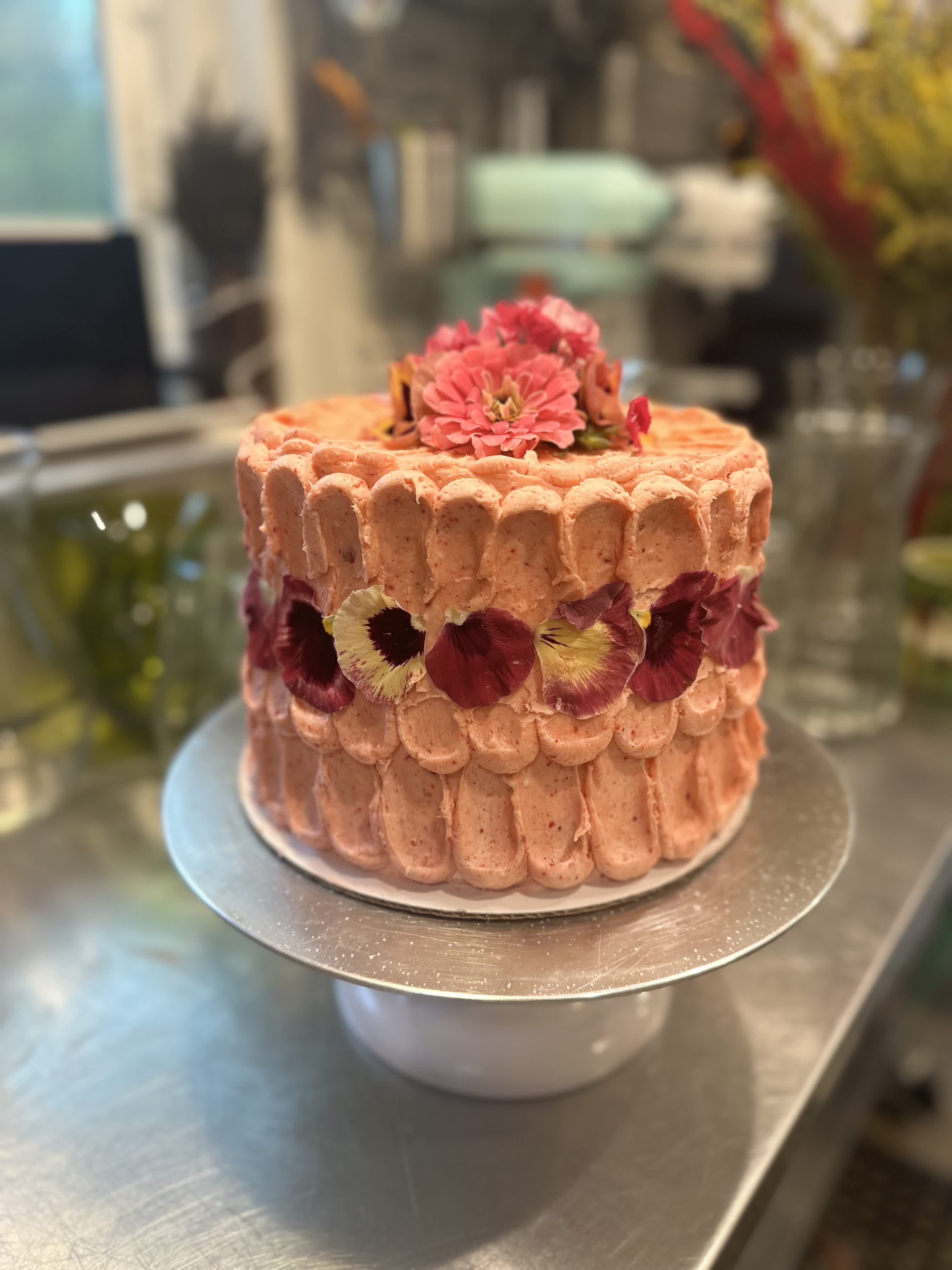 Pink frosted cake decorated with edible flowers