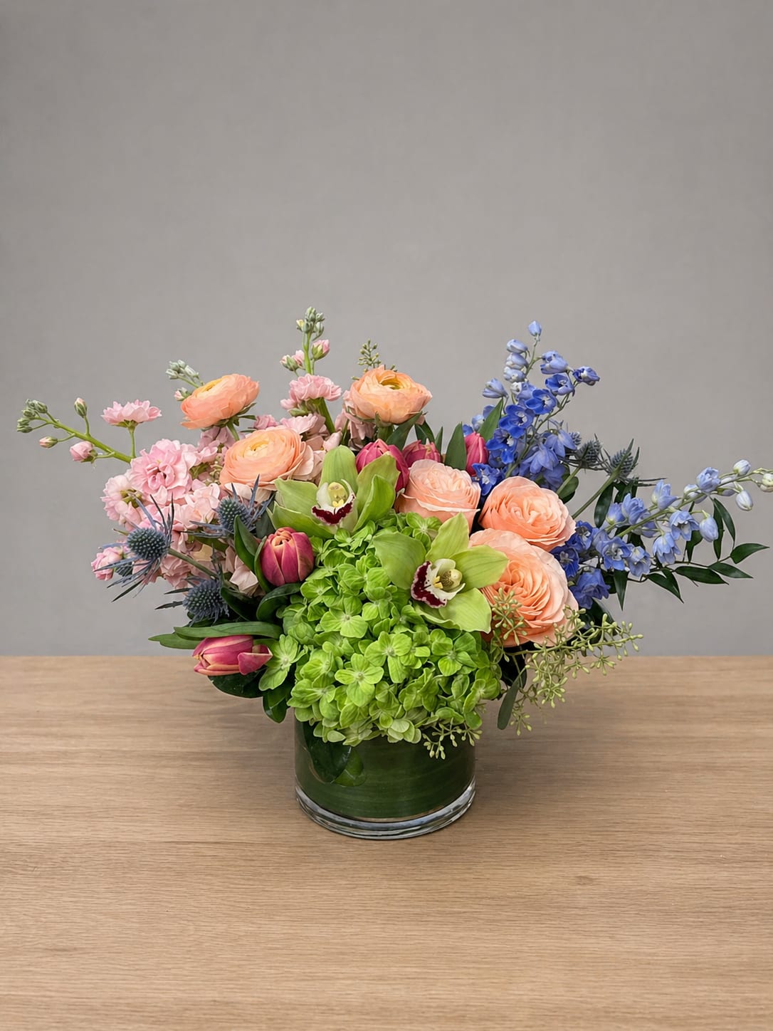     Blooming Joy for Mom - A lush and artfully composed garden arrangement showcasing premium blooms in a harmonious blend of soft pastels and vibrant accents. With its airy movement and layered textures, this design captures the beauty and joy of a spring garden in full bloom.