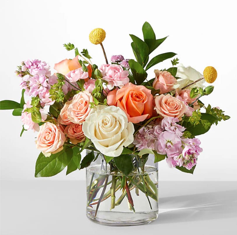 Mixed pink and peach roses in a clear glass vase