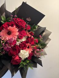 Wrapped Mixed Flower Bouquet - A beautifully handcrafted bouquet featuring a curated selection of fresh, mixed flowers. Each arrangement is uniquely designed, making every bouquet one-of-a-kind—no two are ever the same. Colors and flower varieties may vary, adding a special and personal touch to every creation.  Customize your bouquet by choosing your preferred wrapping paper color: white, black, pink, or purple for the perfect presentation.  All our bouquets are thoughtfully designed to impress and are ideal for expressing deep love, appreciation, and heartfelt emotions.