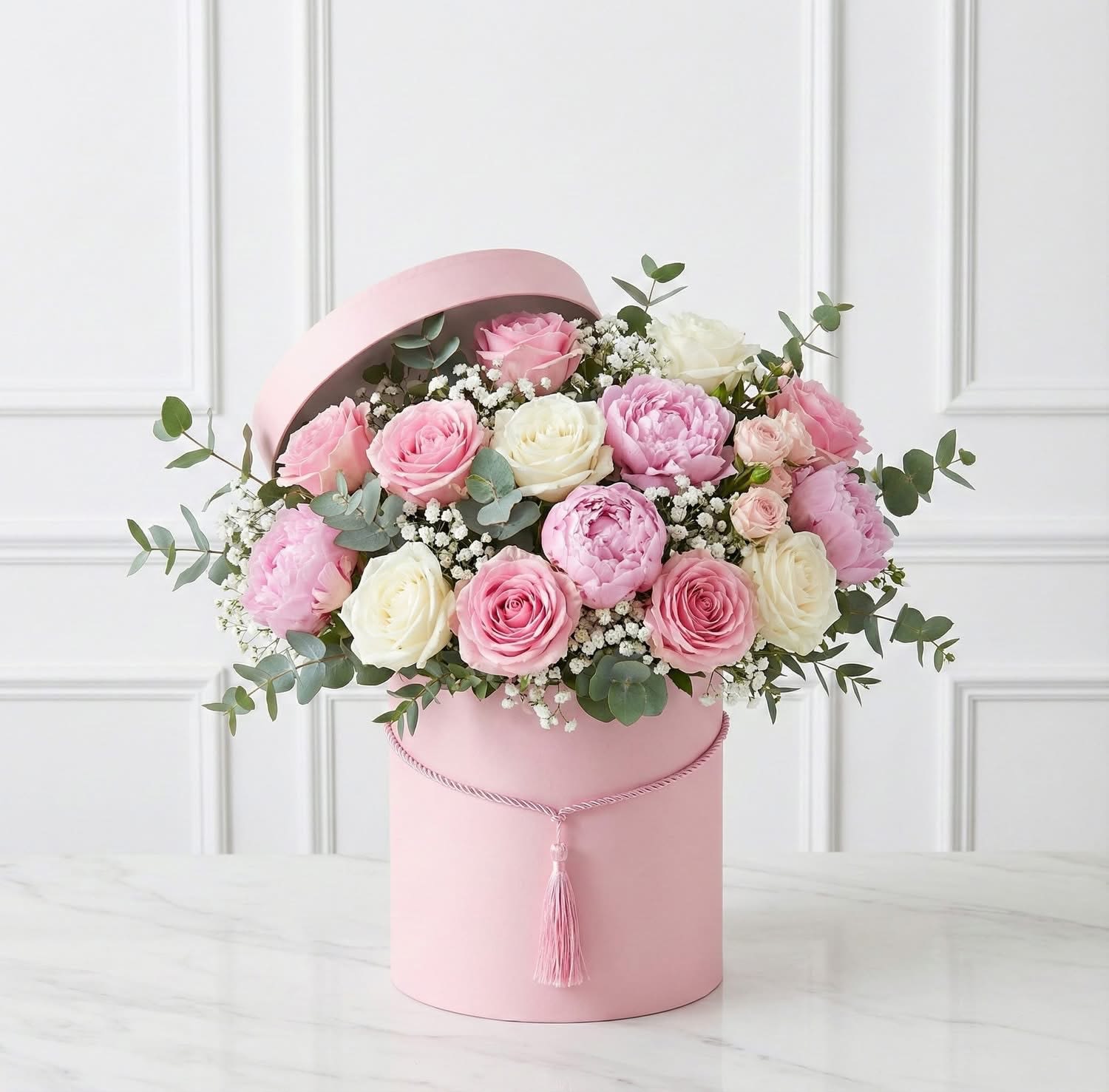 Mixed Roses Box with Eucalyptus - An elegant arrangement of fresh mixed roses beautifully complemented with fragrant eucalyptus, carefully designed in a stylish box. Available in your choice of pink, white, or black box to match any occasion or personal style.  This stunning floral piece is a unique and thoughtful gift, perfect for expressing love, admiration, and appreciation in a sophisticated way.