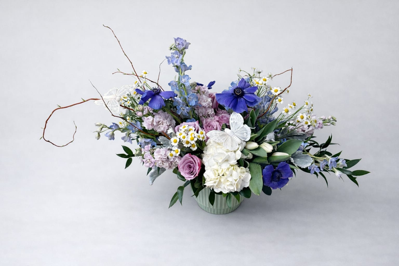     Whispering Garden - A breathtaking garden-inspired arrangement designed with elegance and movement. Featuring premium blooms in soft lavender, blush, and ivory tones, accented with delicate butterflies and airy textures, this design captures the beauty of spring in its most refined form.