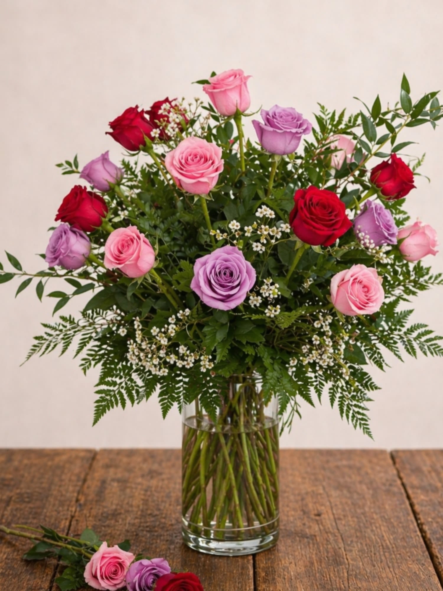 Two Dozen Mixed Roses - Looking for two dozen mixed roses in Round Rock, TX? This premium 24-rose arrangement by Floral Fabulous features a stunning blend of red, pink, and lavender roses, available for same-day delivery.  Make a lasting impression with this lush, hand-designed arrangement of two dozen premium long-stem roses, beautifully styled in a clear glass vase with fresh greenery and delicate filler flowers for a soft, garden-inspired look.  Perfect for anniversaries, birthdays, romantic gestures, or just because, this arrangement delivers elegance, color, and meaning in every stem.  Designed by your trusted local florist on Mays Street in Round Rock, TX, Floral Fabulous is known for high-end floral designs and reliable same-day flower delivery throughout Round Rock and nearby areas.   24 premium long-stem roses  Mixed colors: red, pink, and lavender  Arranged in a clear glass vase  Accented with fresh greenery and filler flowers  Same-day flower delivery available in Round Rock, TX