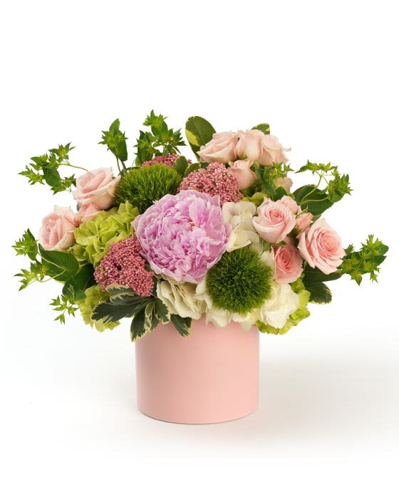 Ruffled Charm - A delicate gathering of ruffled pink blooms, soft accents and fresh greenery styled in a sweet ceramic vase.