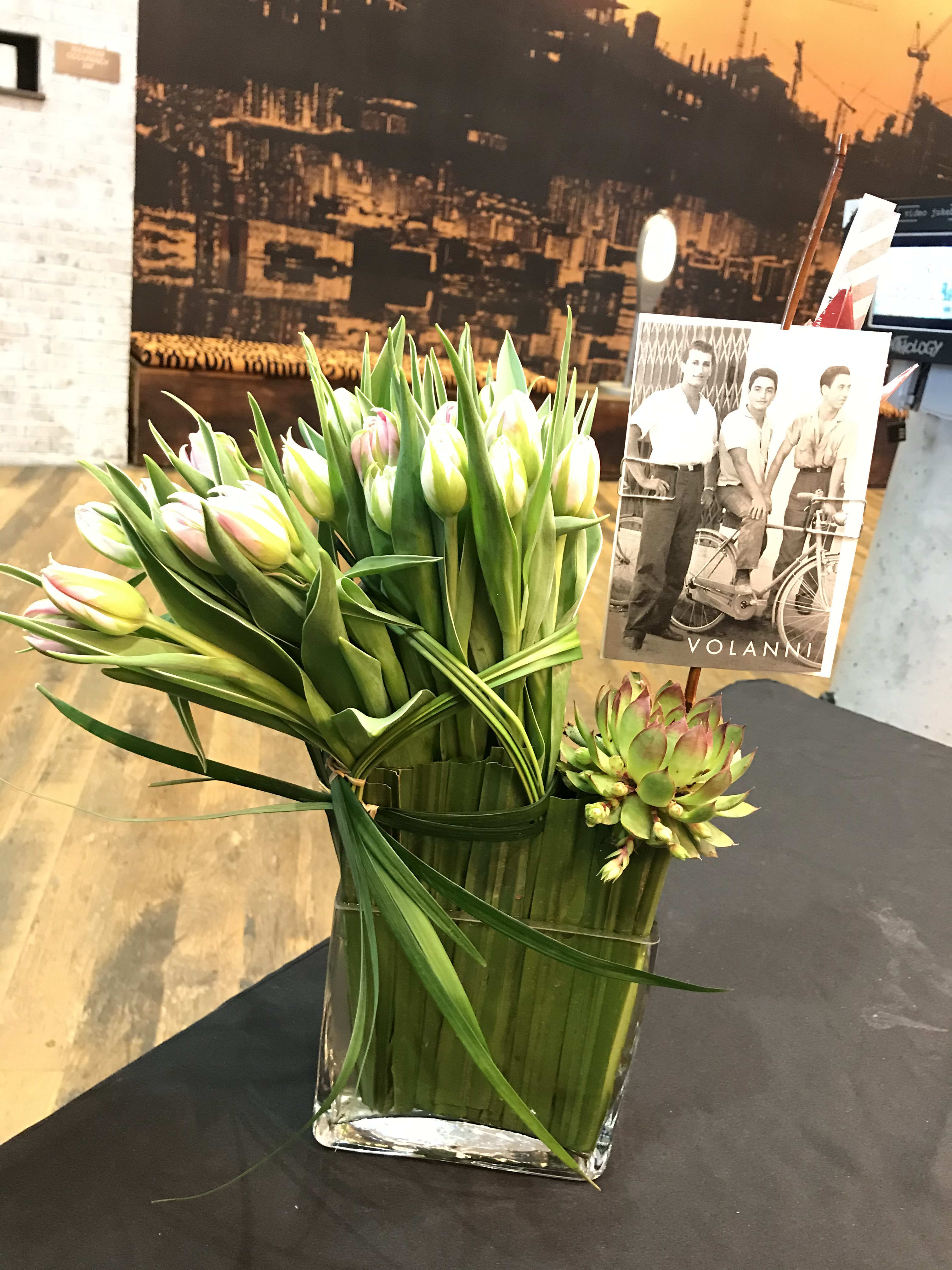 Tulip bouquet in a clear rectangular vase with a succulent accent