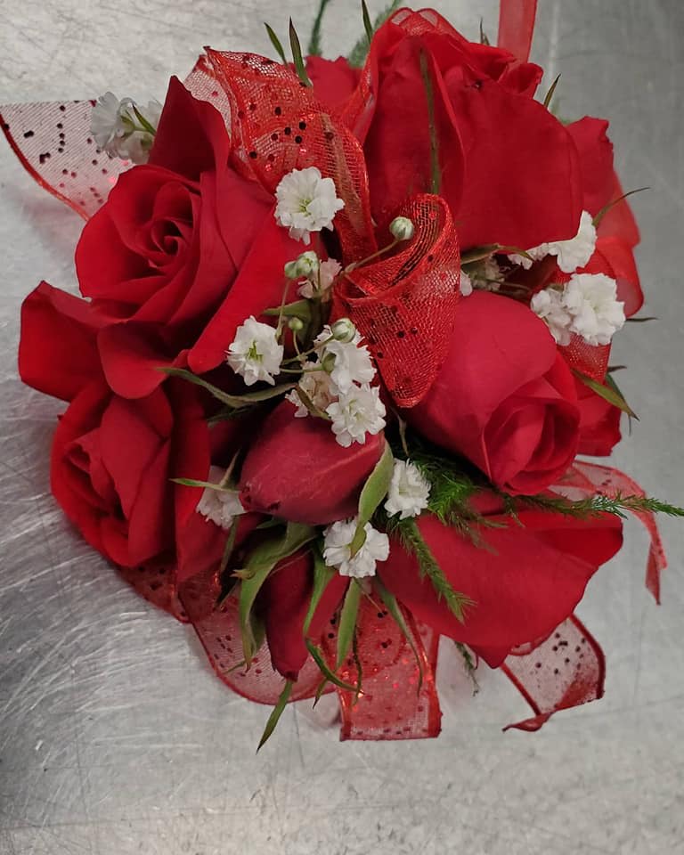 Bouquet of red roses with small white filler flowers and red mesh ribbon