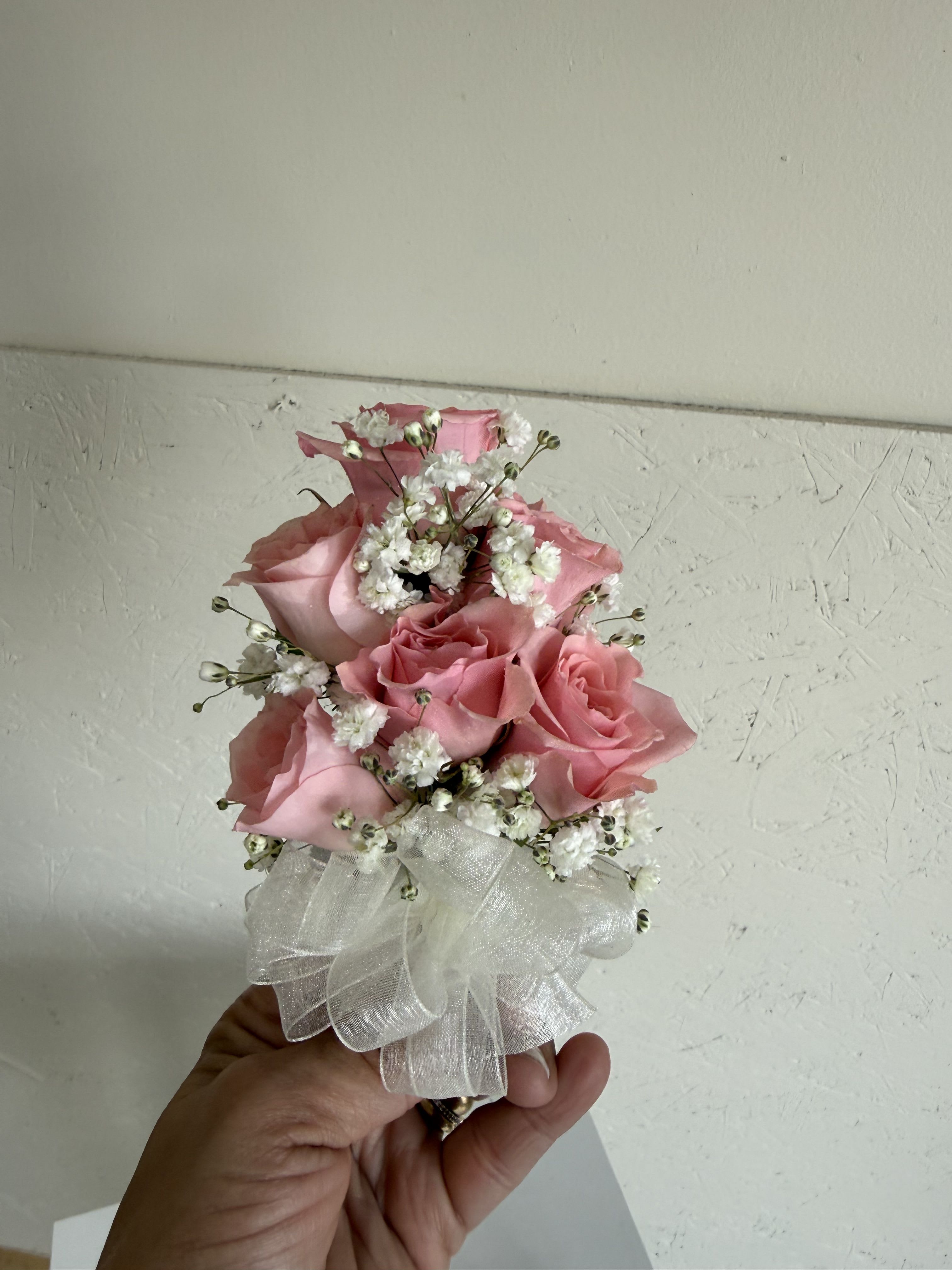 Crimson Classic Corsage - A delicate wrist corsage with rich red roses and soft greenery for a classic touch.