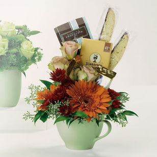 A Whole Latte Fun - Cocoa mix, chocolates and biscotti accompany a cappuccino mug brimming with Gerbera daisies, roses and pompons. A Whole Latte Fun to send and receive!