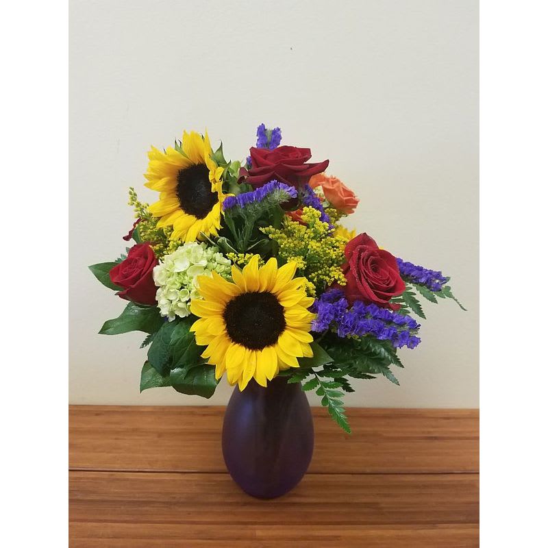 Bright Colorful Summer Vase - Bright as a hot summer day. A splendid vase of green mini green hydrangea, red roses, sunflowers, orange spray rose would be great for any occasion. 