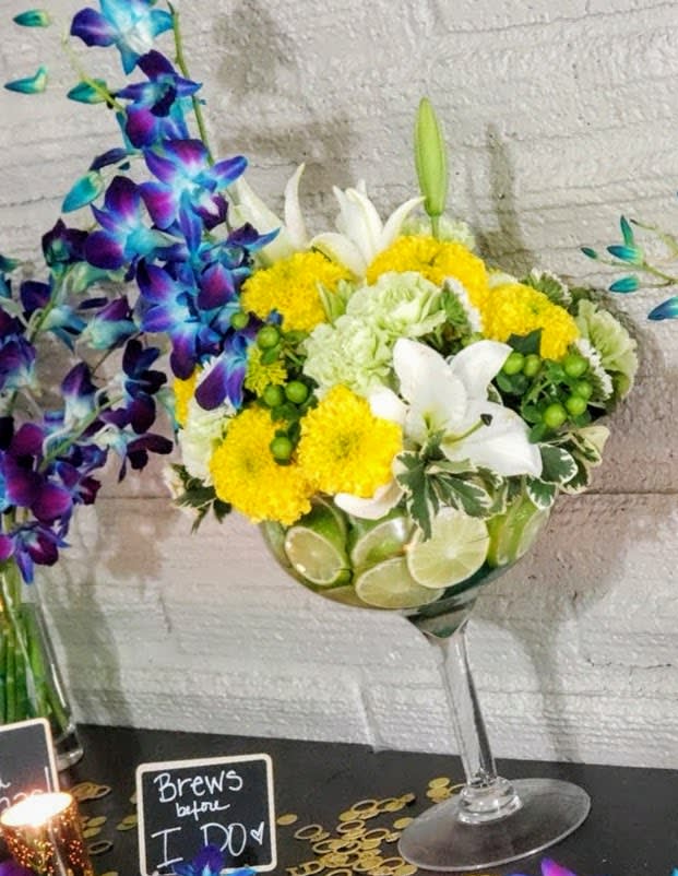 Mamacita needs a Margarita - Is mama having a rough day. Here is a fun way to brighten here day.  She will recive a festive floral arrangment in a large Margarita glass. Great also for parties too.  ****Orchid color may very depending on availability*****  