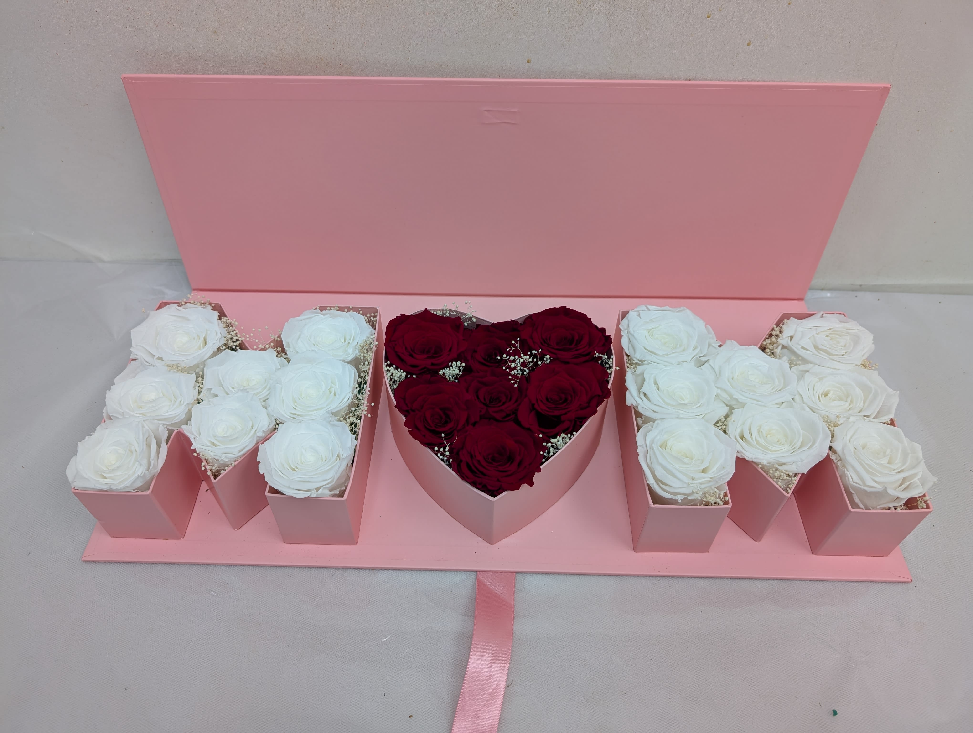 Pink gift box with white and red roses arranged in compartments