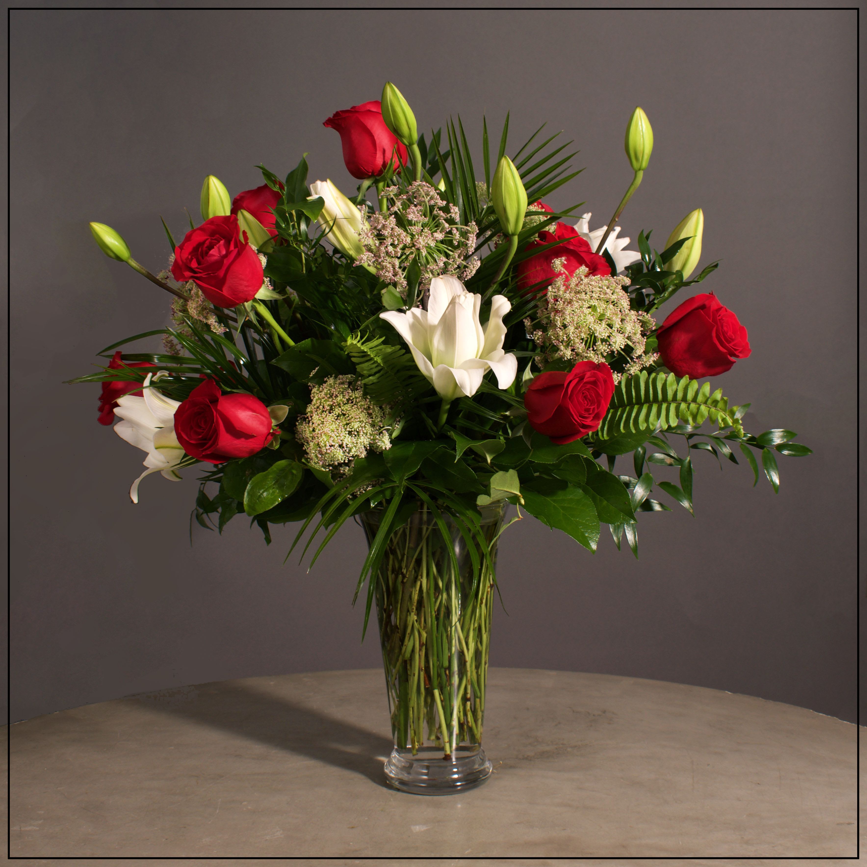 Red roses and white lilies in a clear glass vase
