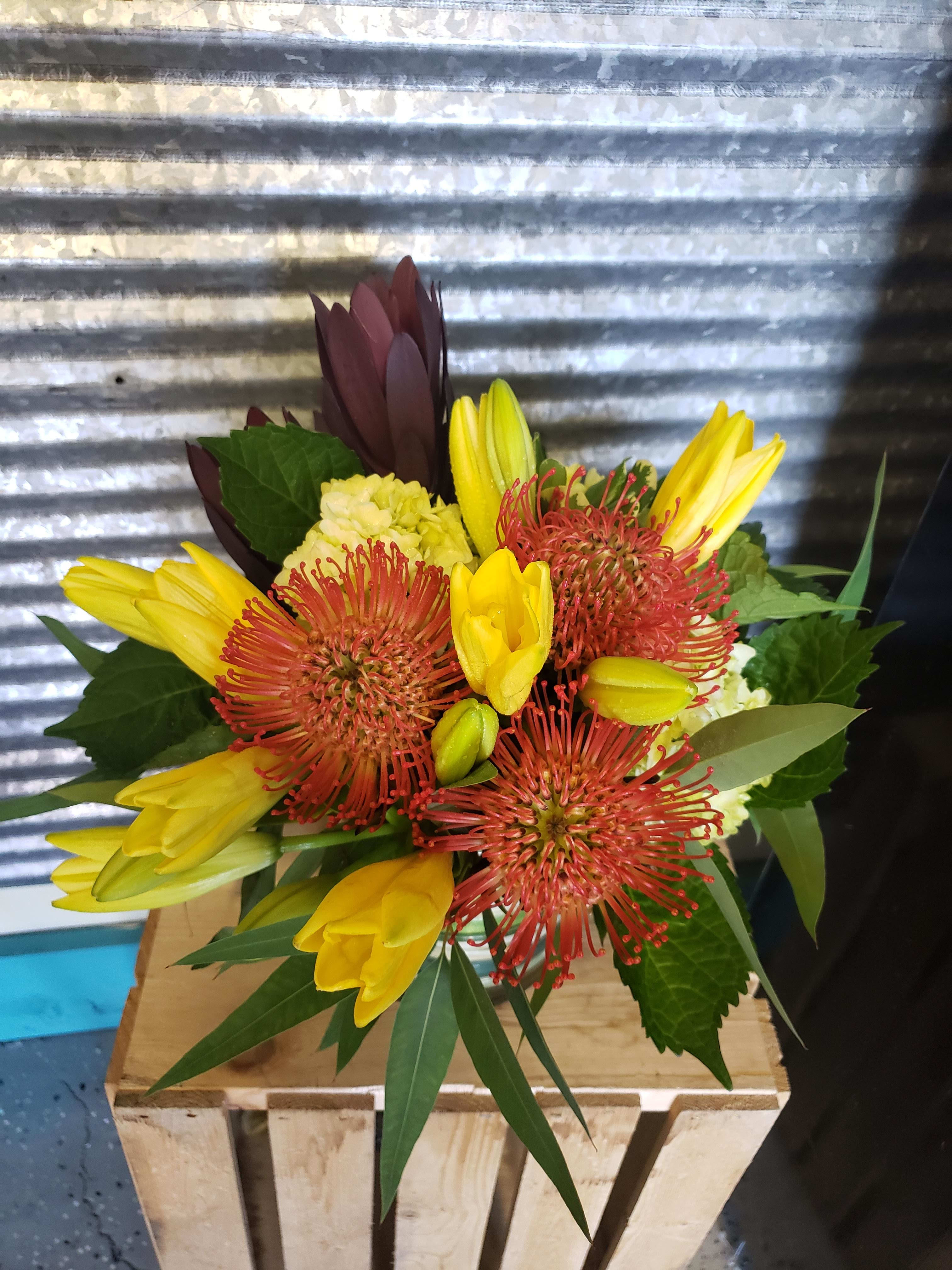 Tropical Sunset  - Bright arrangement of yellow lilies and Pincushion, Safari Sunset Protea  that will remind you of the a tropical sunset      