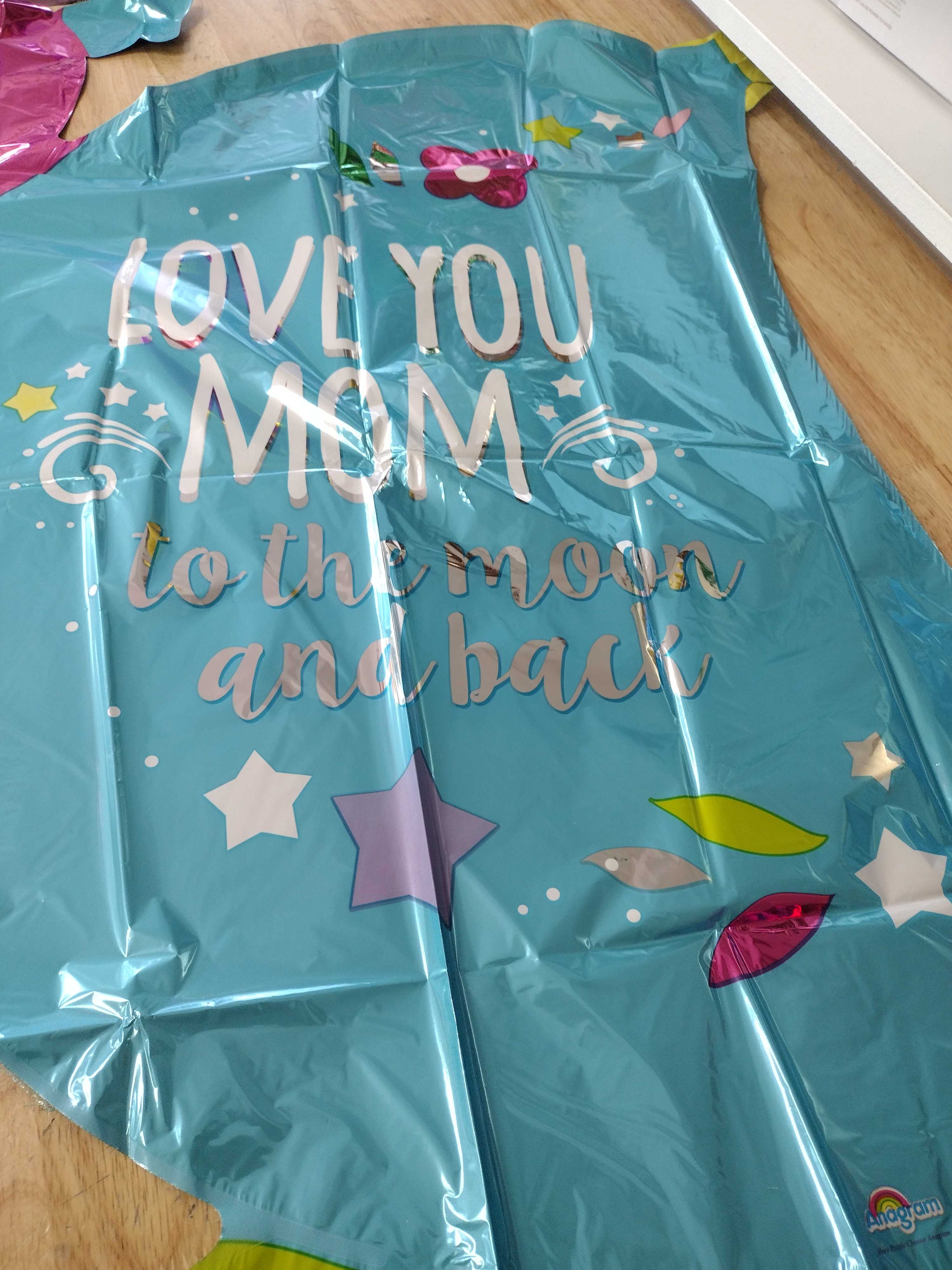 Blue foil balloon with the words "Love you Mom to the moon and back"