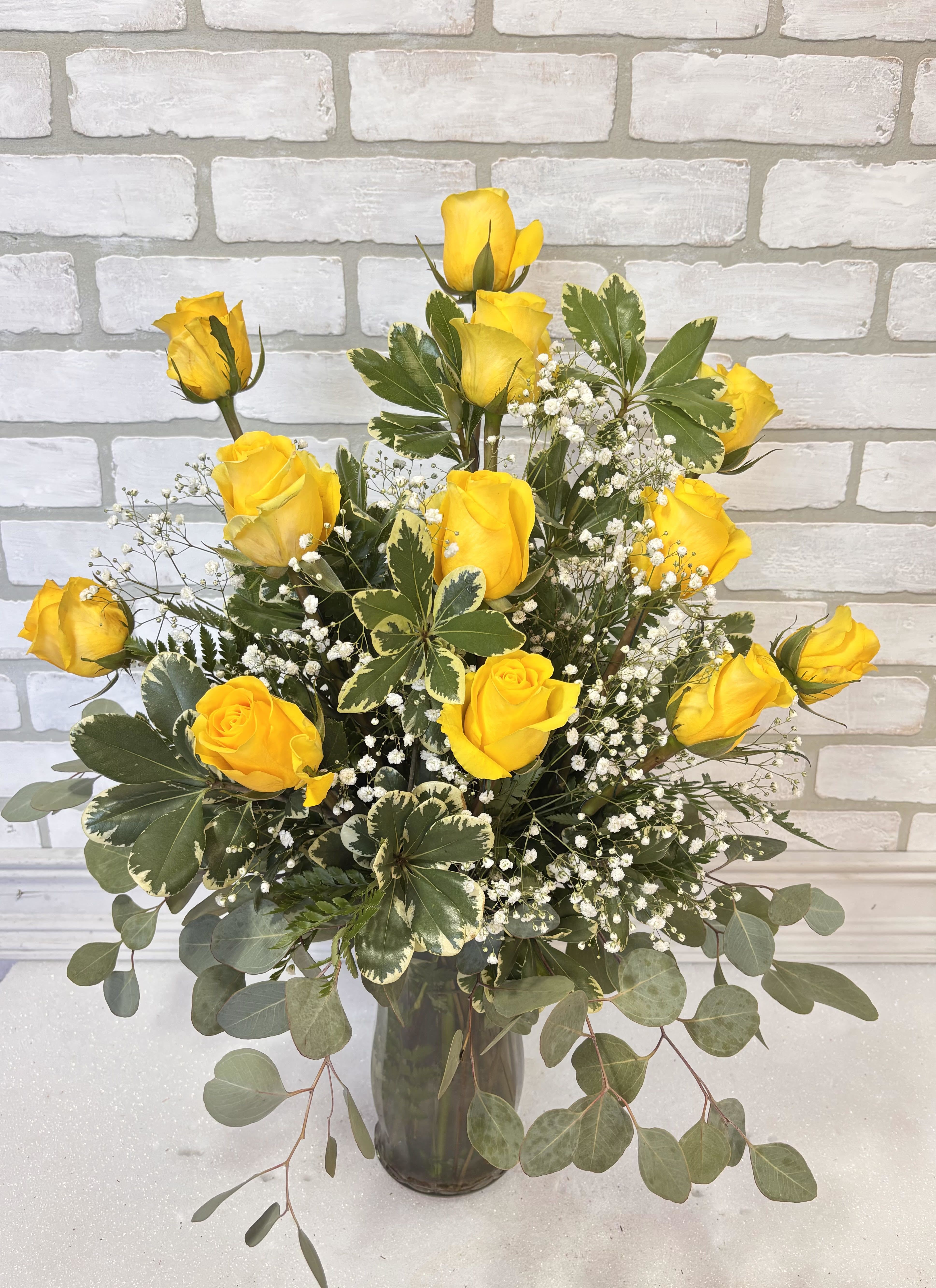 Dozen Yellow Roses - A dozen yellow roses arranged in a vase with filler and greenery.   *Yellow roses primarily symbolize friendship, joy, and warmth, representing happiness, appreciation, and new beginnings.*