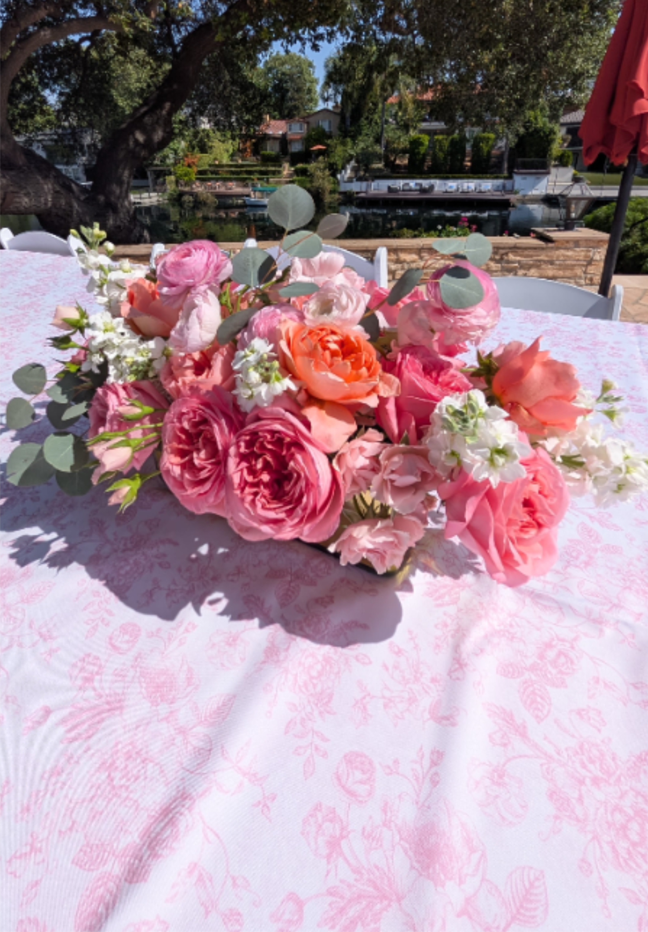 Blushing Meadow - Lush, low-profile centerpiece of roses, ranunculus, &amp; silver dollar eucalyptus