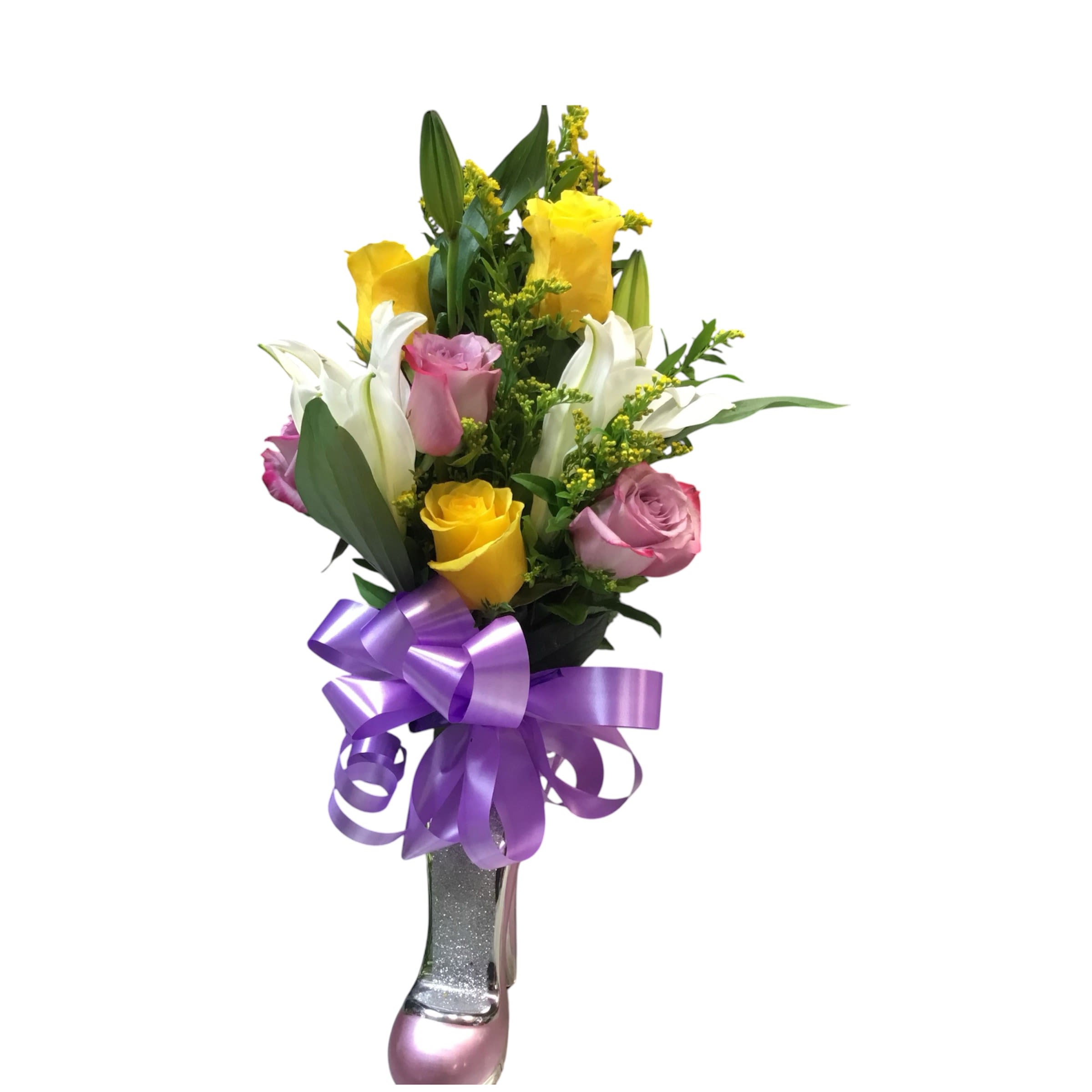 Floral slipper - A tall, upright Floral slipper arrangement that brightens any birthday, anniversary, or congratulatory moment with a cheerful mix of yellow and pink roses and elegant white lilies. The vertical silhouette and glittery vase give this flower arrangement a celebratory, slightly romantic feel-perfect for the person you want to make feel seen and special on a milestone or festive occasion.  This bouquet pairs sunlit yellow and soft pink roses with fragrant white lilies and small yellow filler blooms, all set against dark green foliage for crisp contrast. Blooms are arranged upright in a narrow, glittery silver-and-pink vase and finished with a large lavender-purple ribbon tied at the base, creating a polished, gift-ready presentation that reads both joyful and refined.  A thoughtful choice for celebrations, table-top displays, or as a standing gift at a party, this arrangement delivers an immediate impression of warmth and affection. Designed to be enjoyed on arrival, trim stems and refresh the water every few days to extend vase life; available in the pictured compact upright size ideal for tabletops and entryway displays.